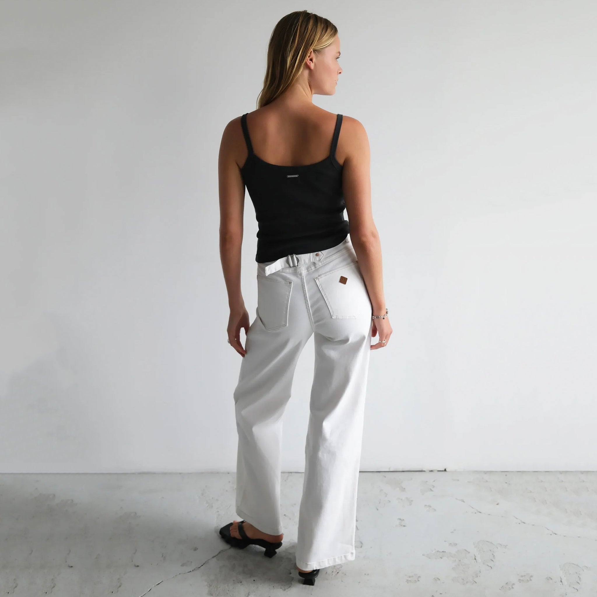 Woman wearing a pair of Abrand 94 High & Wide Jeans in Western White.