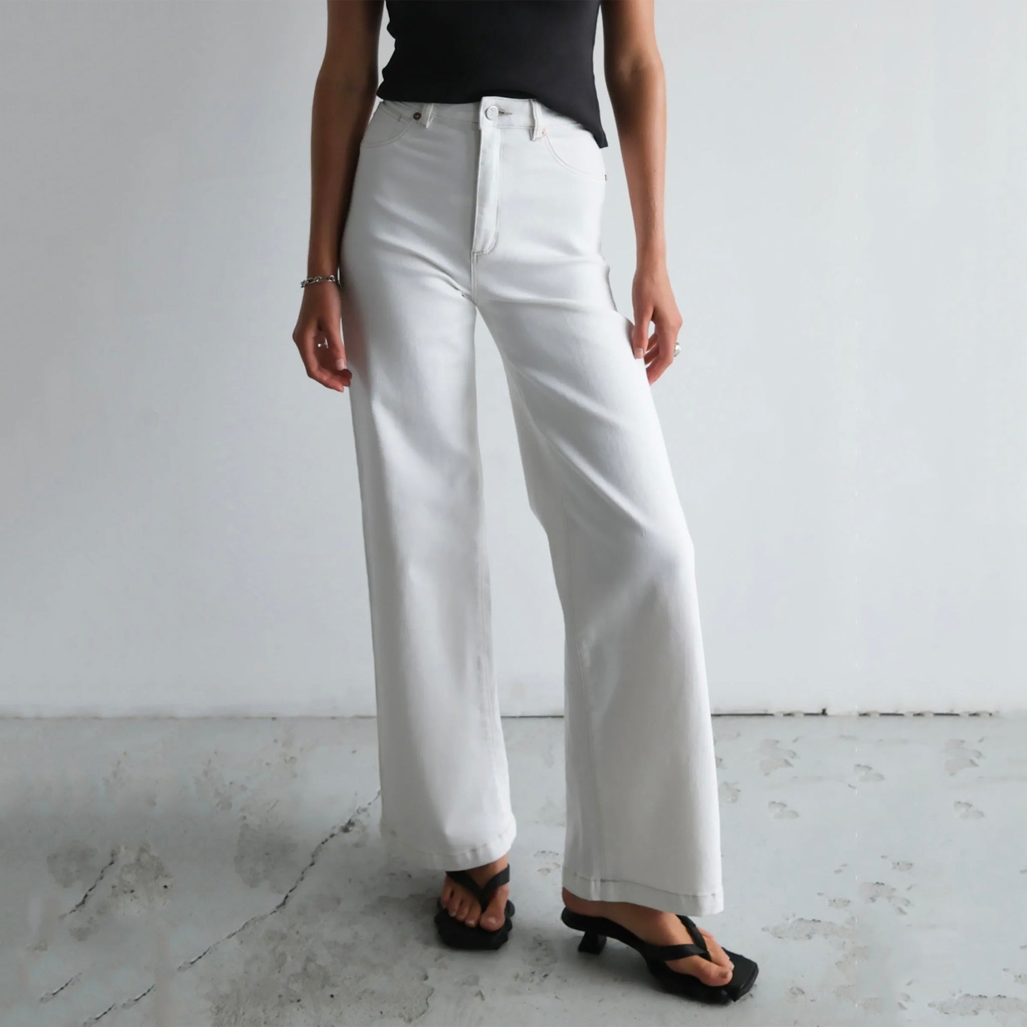 Woman wearing a pair of Abrand 94 High & Wide Jeans in Western White.