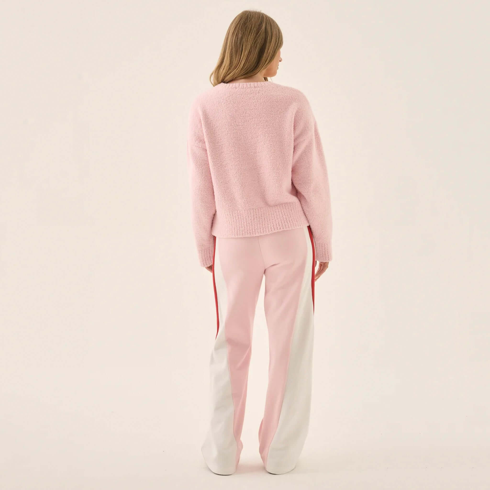 Model wearing the Araminta James Aimes Shell Cardigan - Ballet Pink from the back with pink pants.