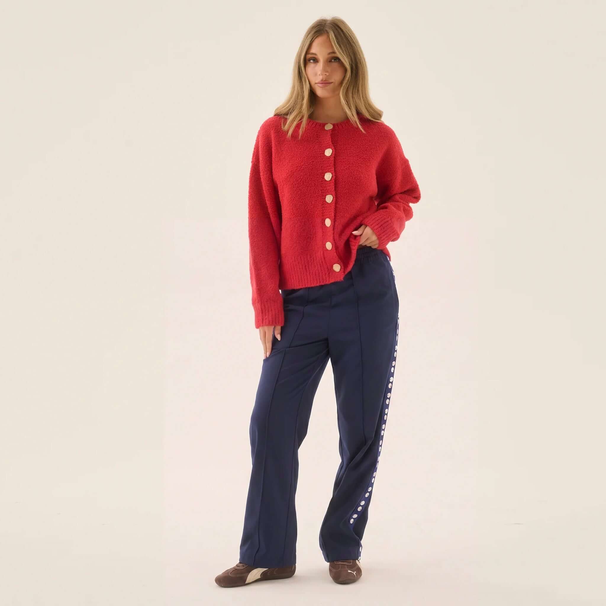 Araminta James Aimes Shell Cardigan - Deep Coral displayed with navy pants and brown shoes.
