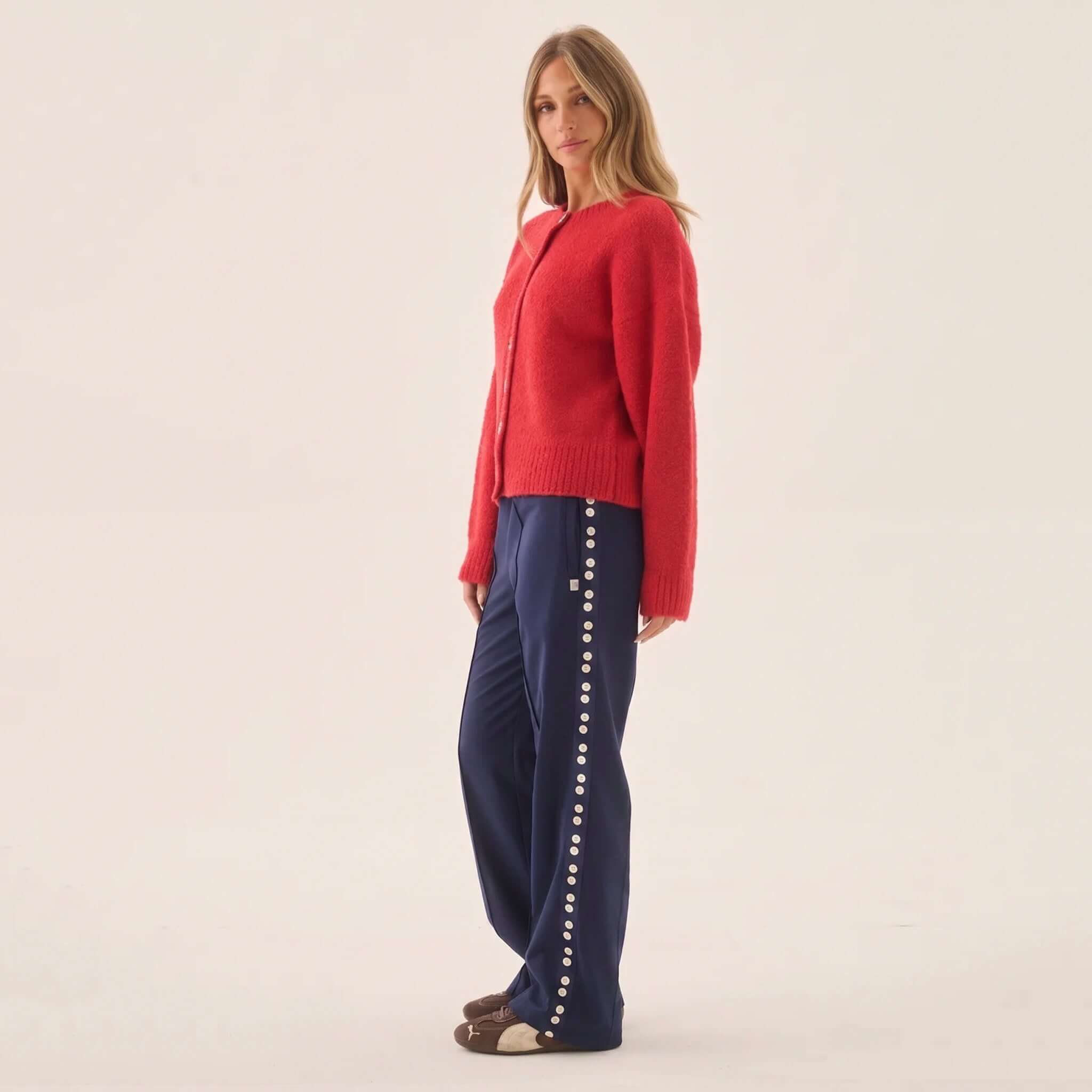 Araminta James Aimes Shell Cardigan - Deep Coral worn with navy pants and cozy footwear.
