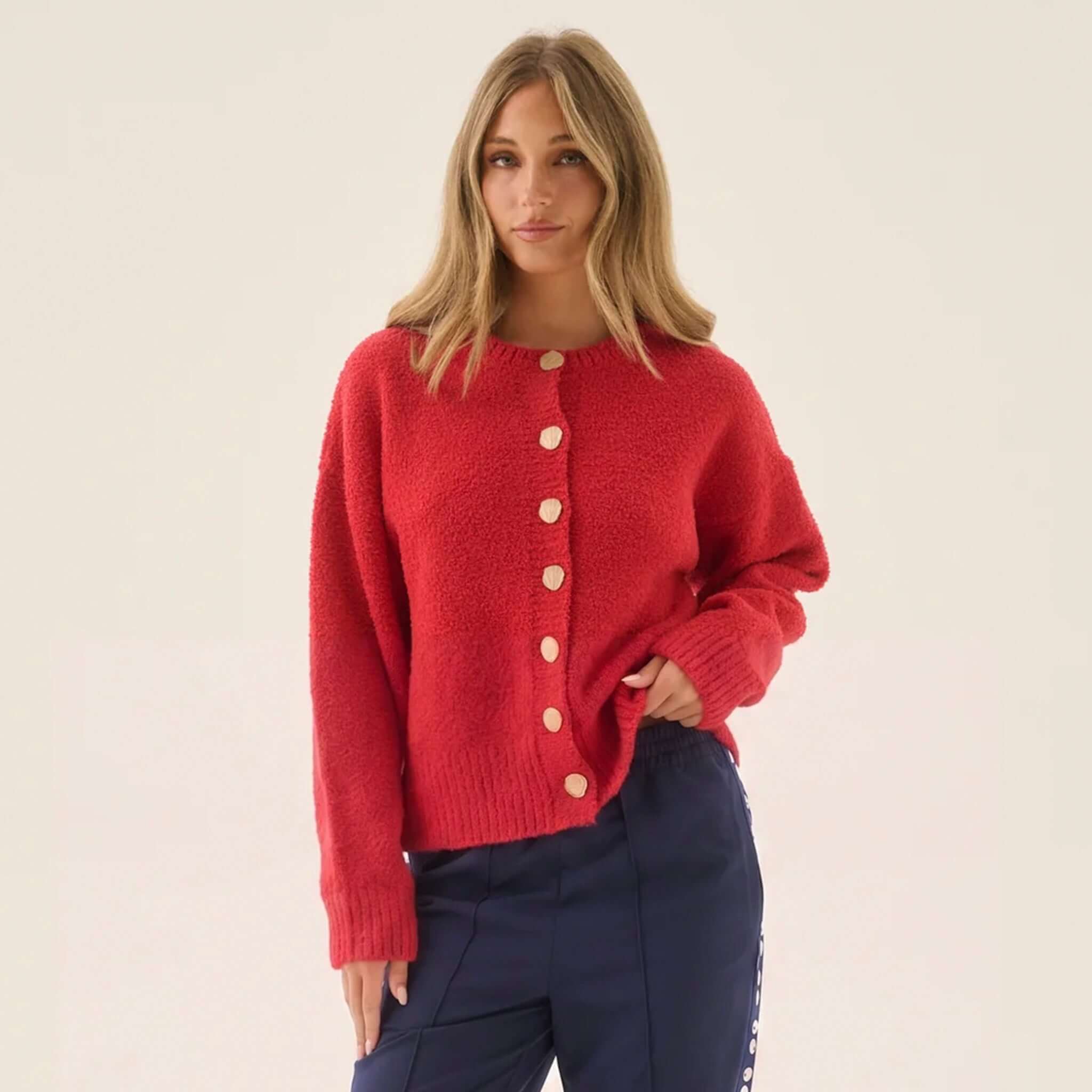 Araminta James Aimes Shell Cardigan - Deep Coral worn by a model, featuring gold buttons and a cozy knit.