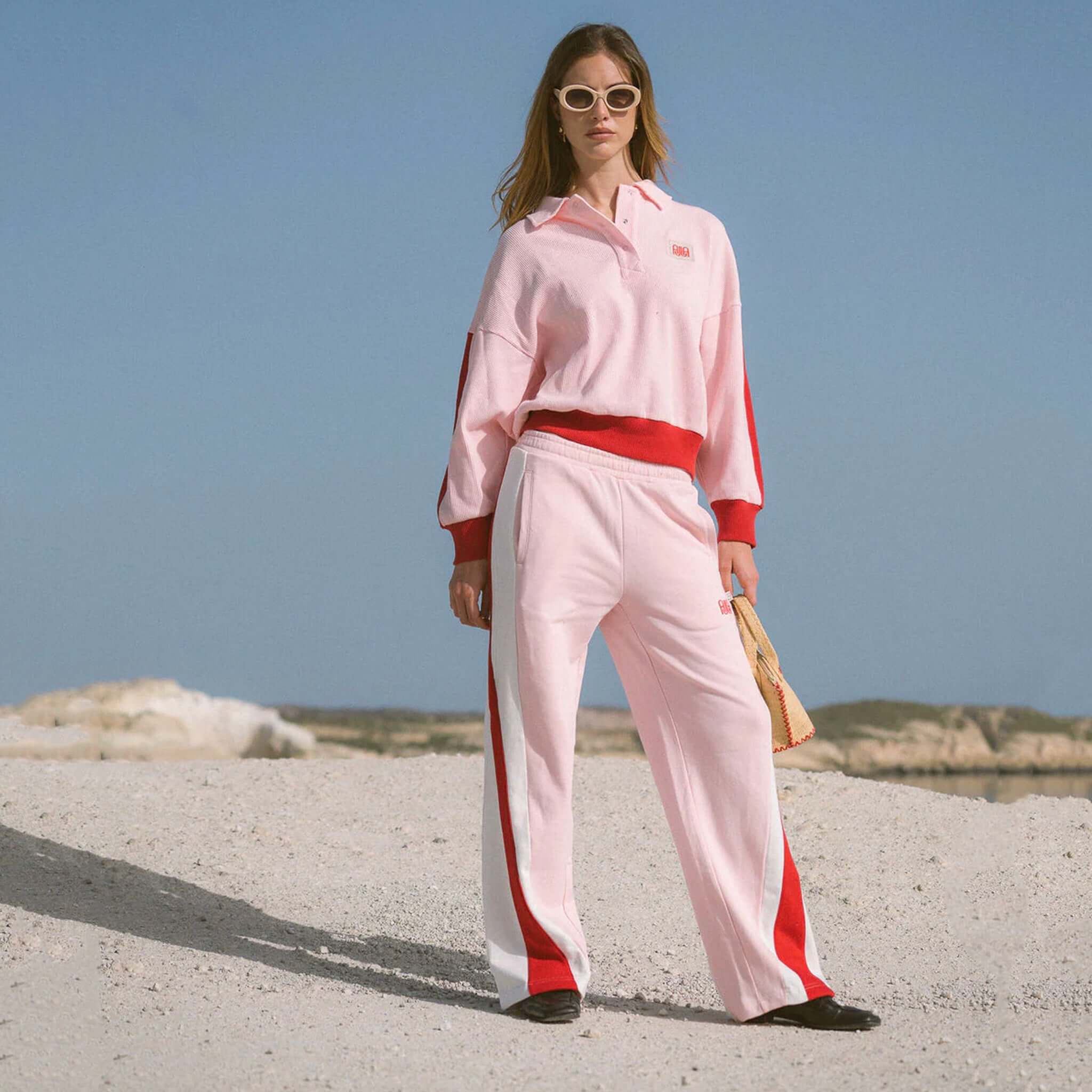 Araminta James Mallorca Trackpants - Ballet Pink worn by model on beach, featuring color-blocked panels and relaxed fit.