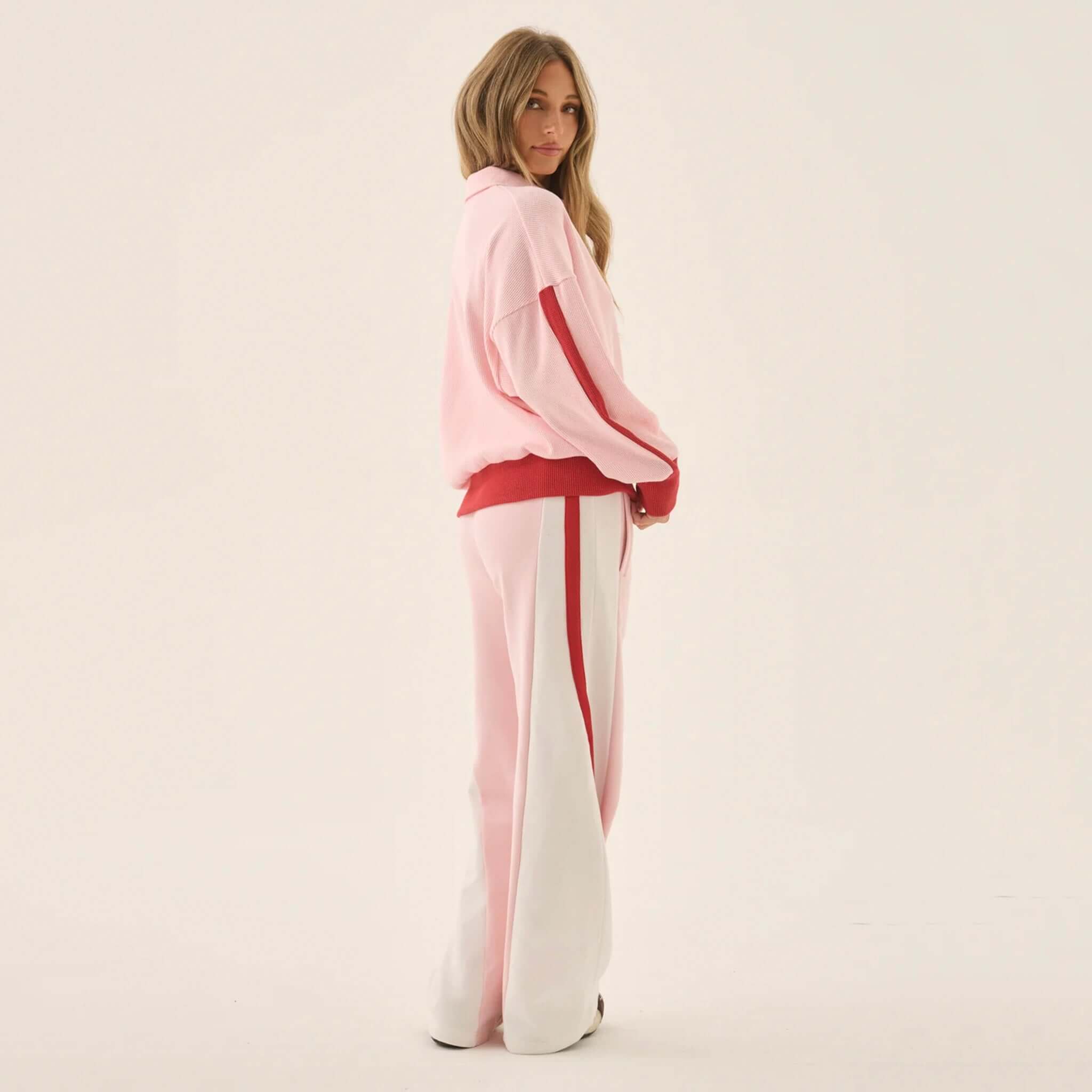 Araminta James Mallorca Trackpants - Ballet Pink model wearing color-blocked trackpants with cream and red side panels.