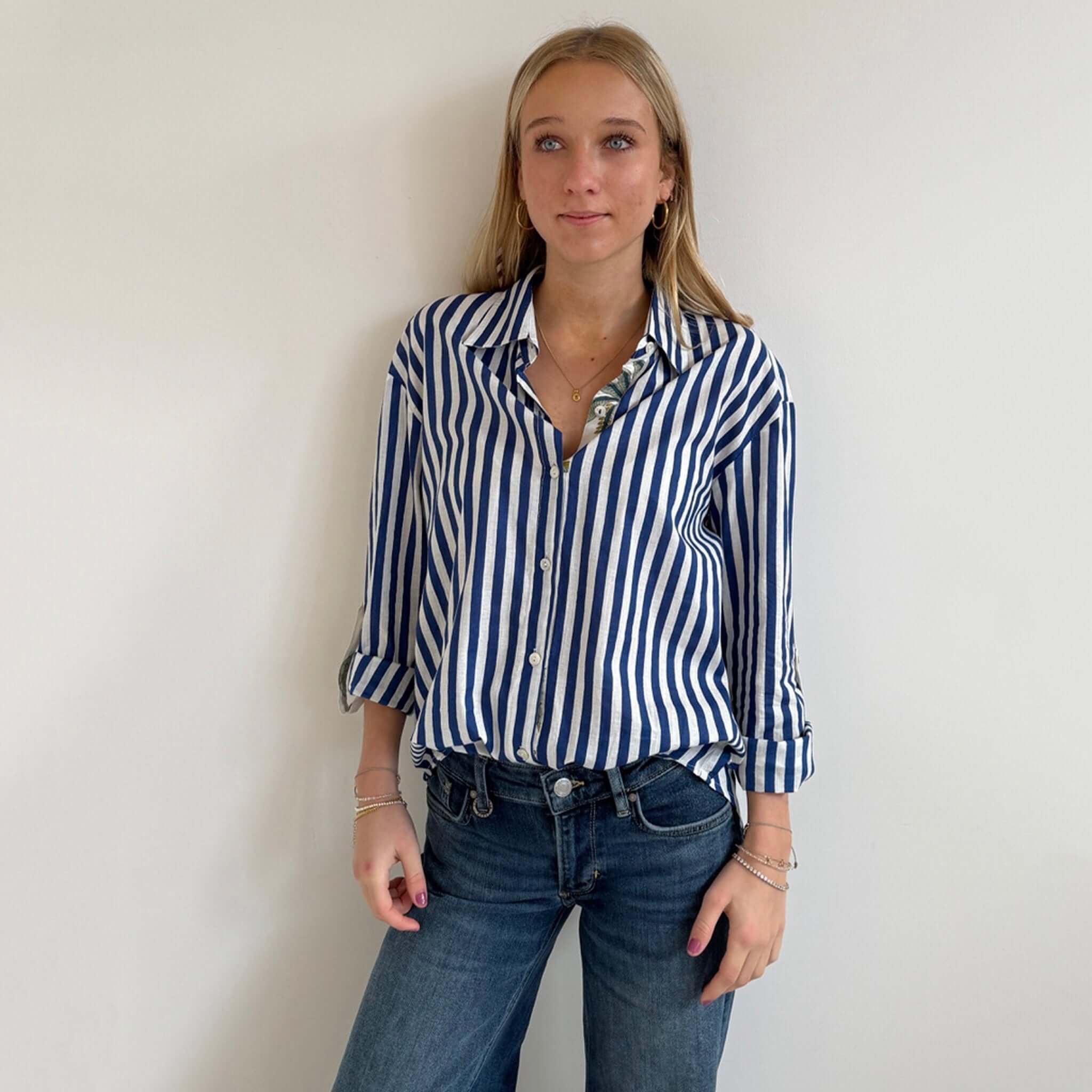 Art In My Wardrobe Annie Shirt -  Blue worn by a model, showcasing bold blue and white stripes with floral details.