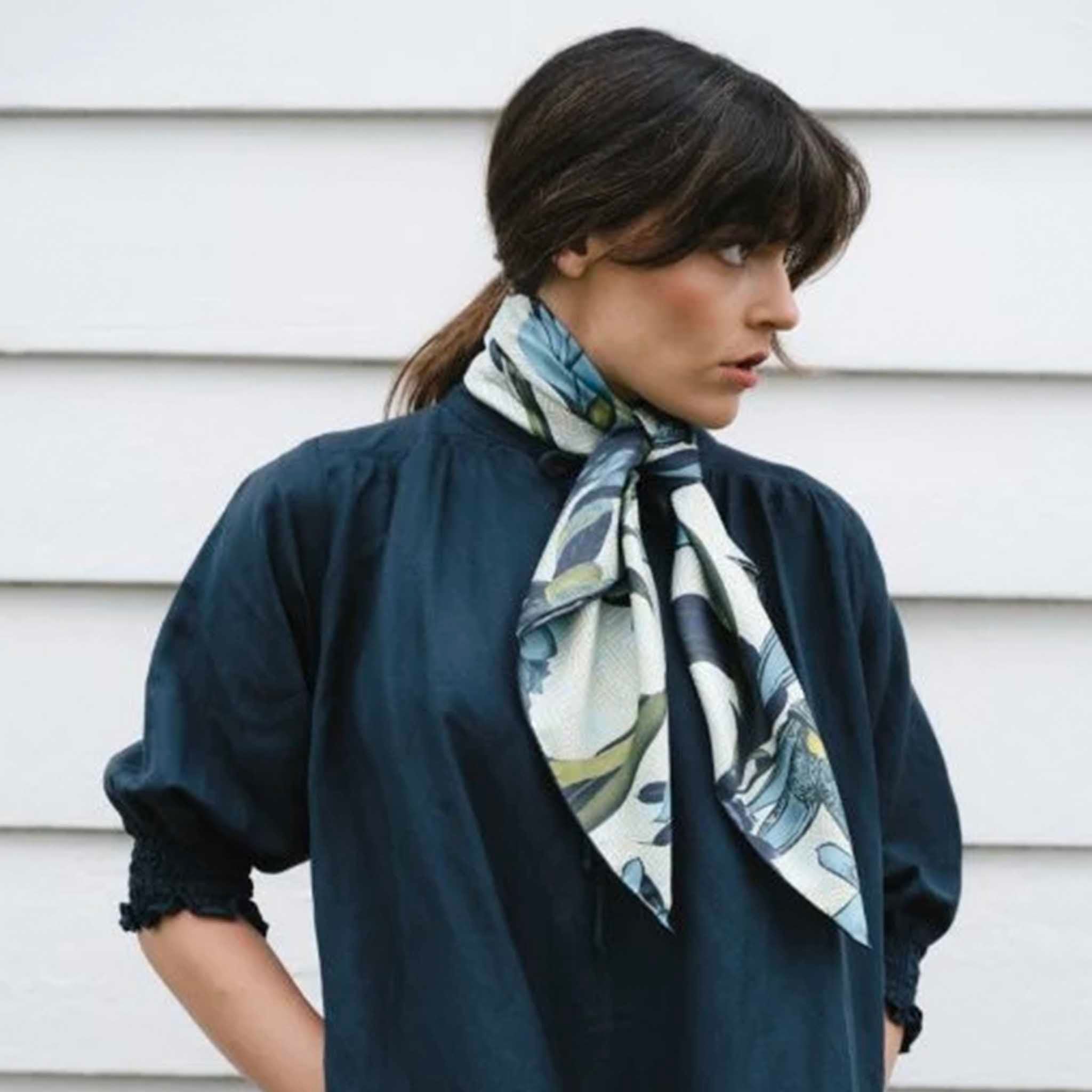 Alt Tag: Artifact Square Silk Scarf - Eos worn around neck, blue and yellow botanical silk twill scarf on model