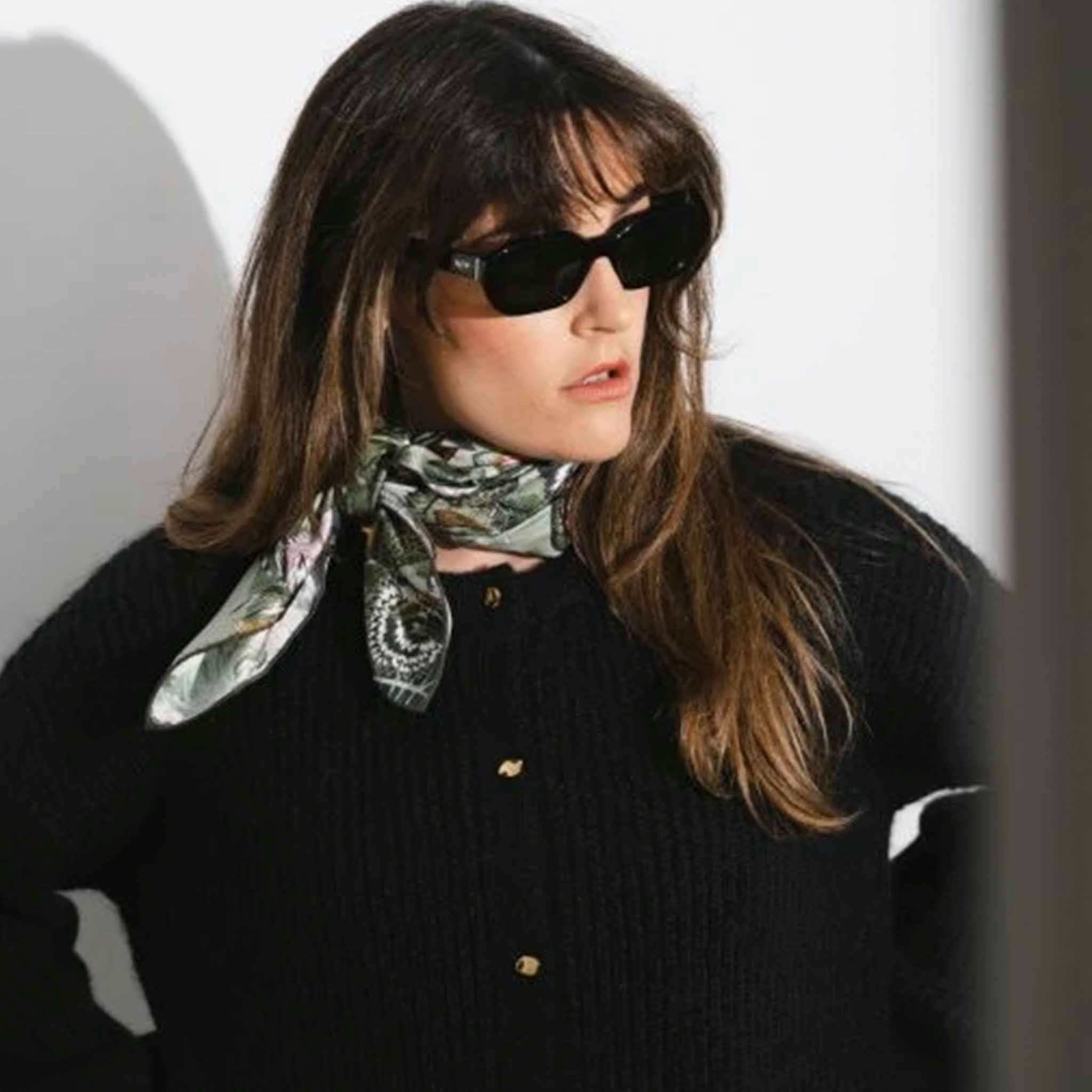 Alt Tag: Artifact Square Silk Scarf - Silva Noire worn as neck scarf on model with black sunglasses, green botanical print silk scarf