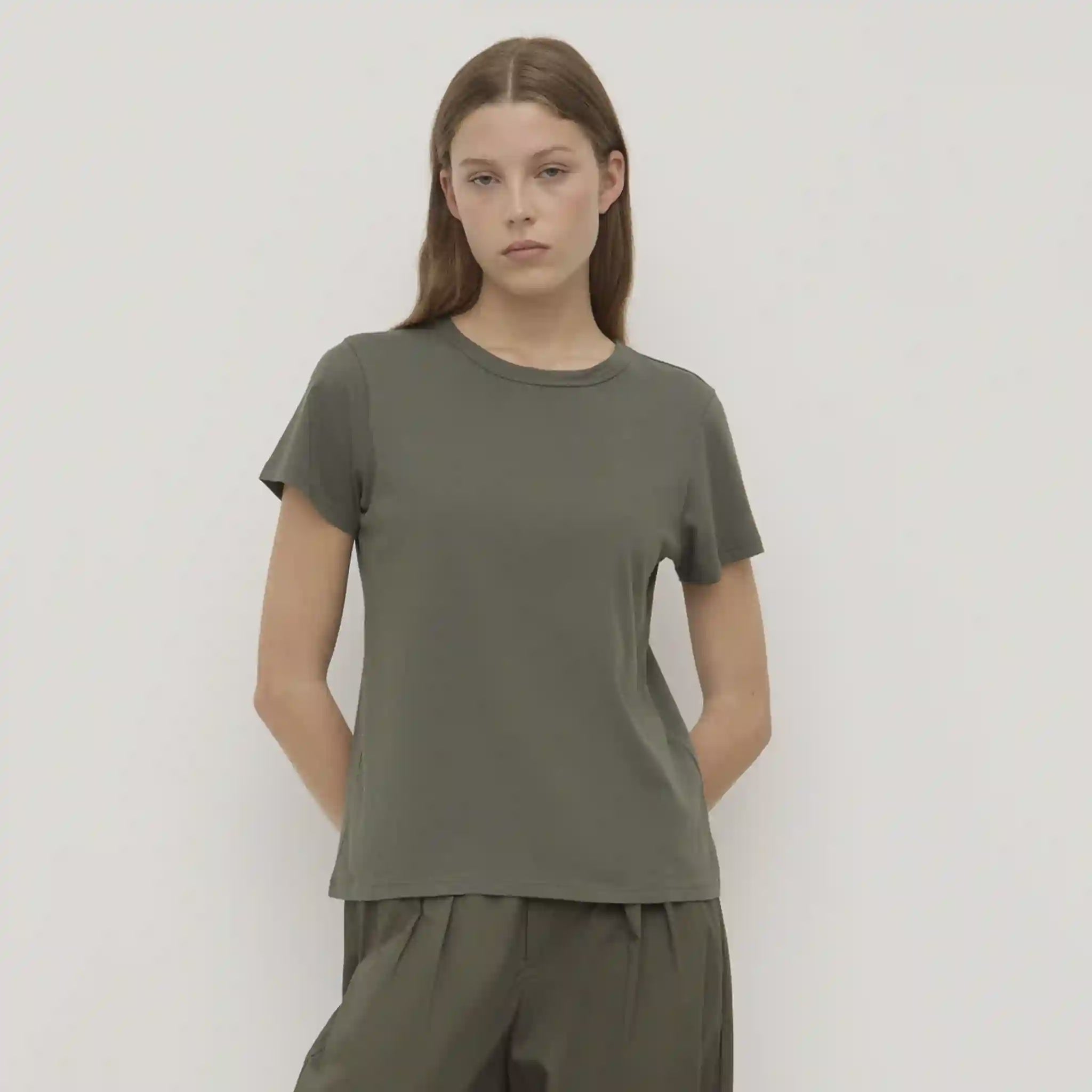 Person wearing a green t-shirt and pants against a white background