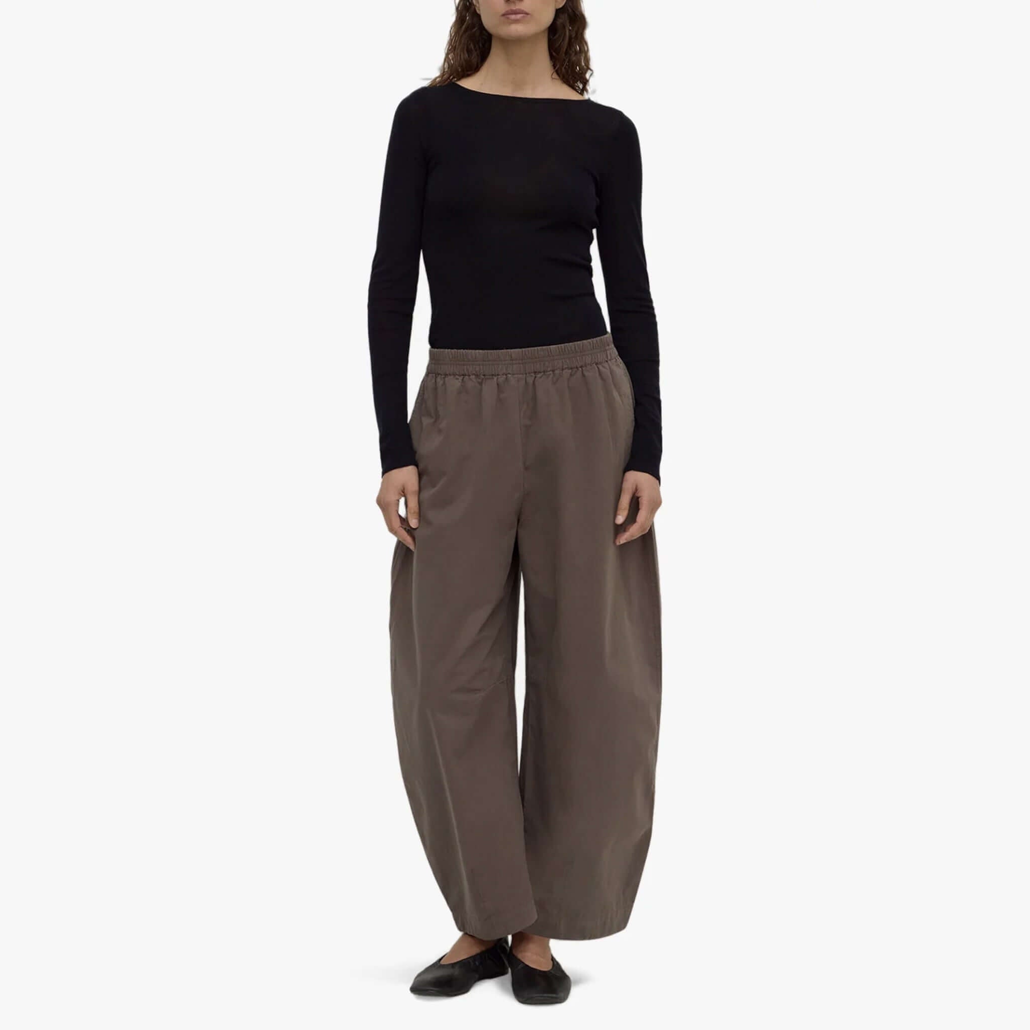 Model wearing Assembly Label barrel pants in bark, featuring a voluminous leg and elasticated waistband.