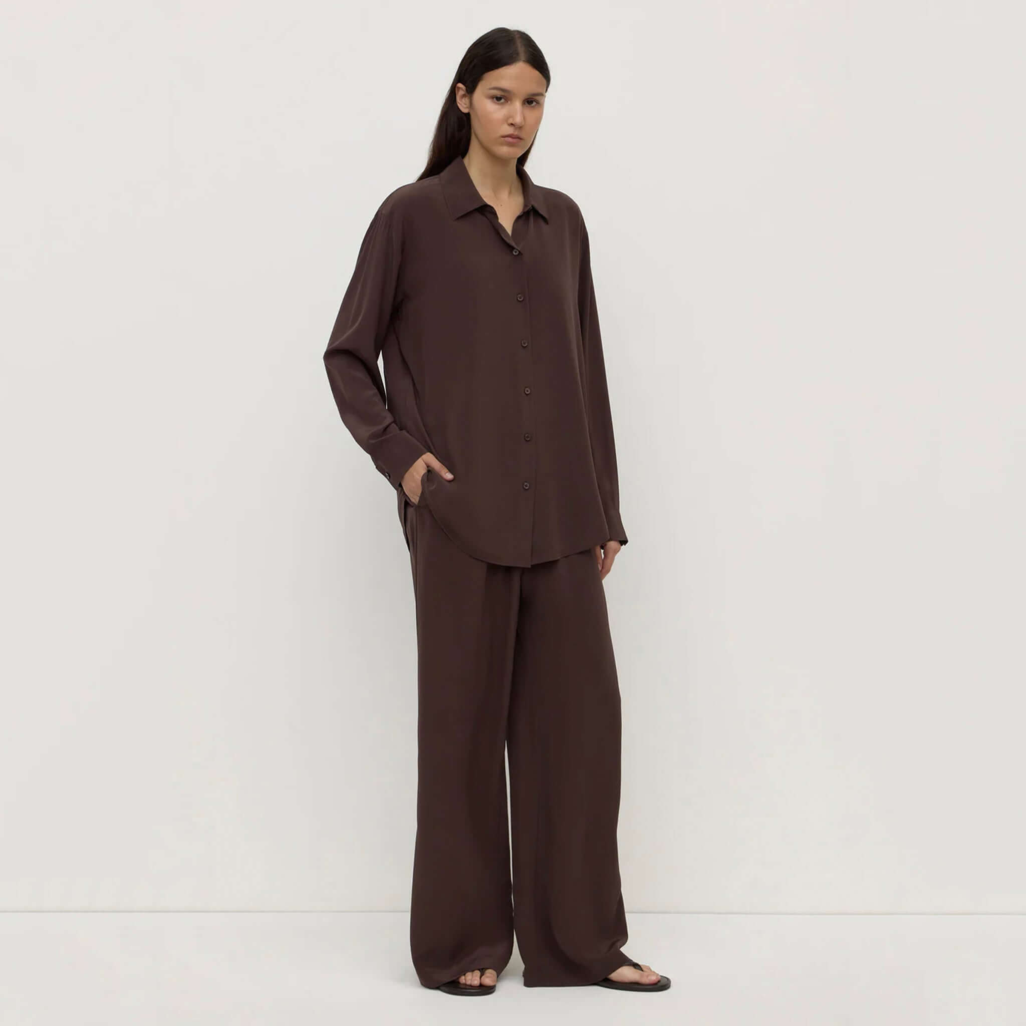 Alt Tag: Assembly Label Betty Silk Long Sleeve Shirt - Ganache worn by model, relaxed button-up silk shirt in rich ganache brown