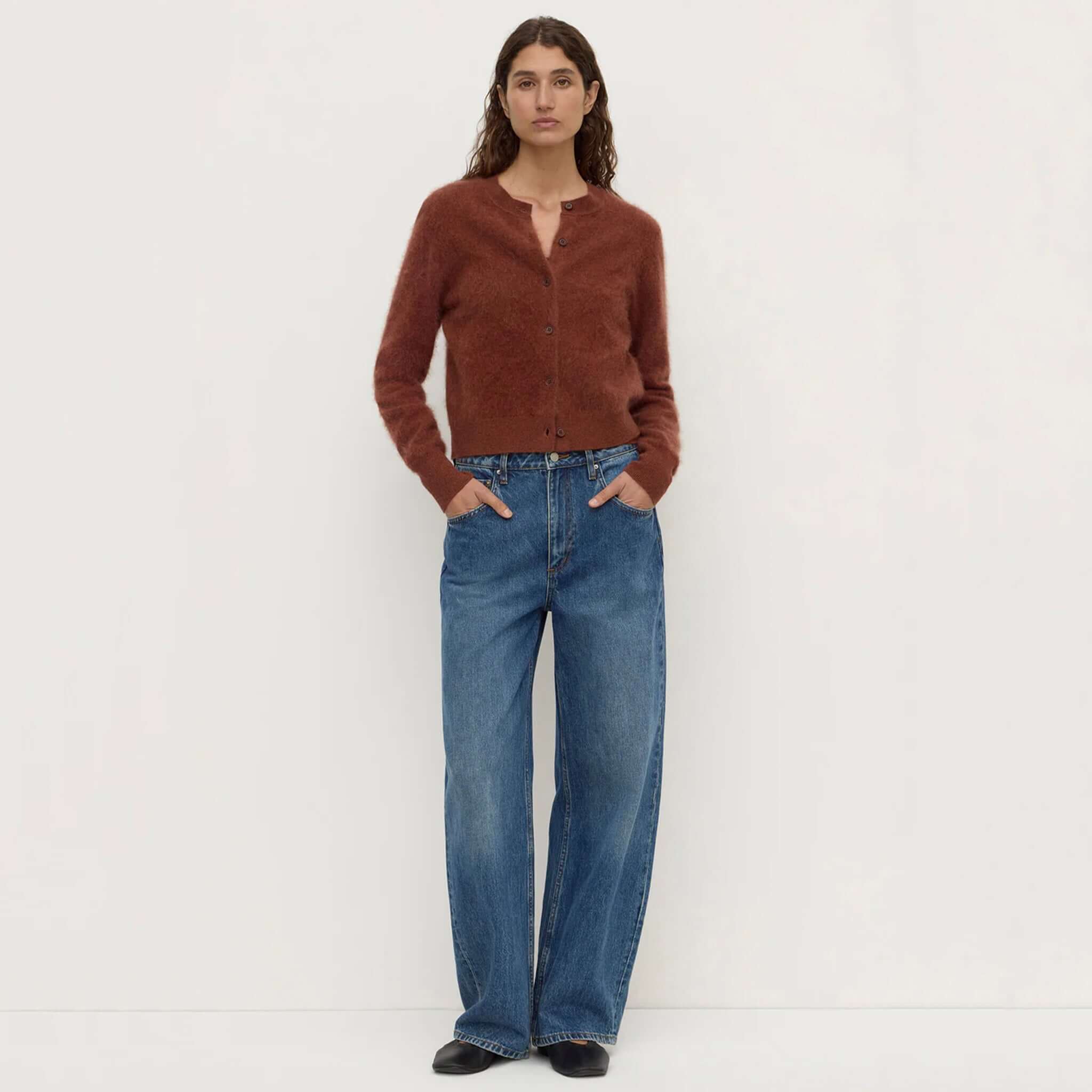 Assembly Label merino wool cardigan Burnt Amber styled with wide-leg jeans and a crew neckline.