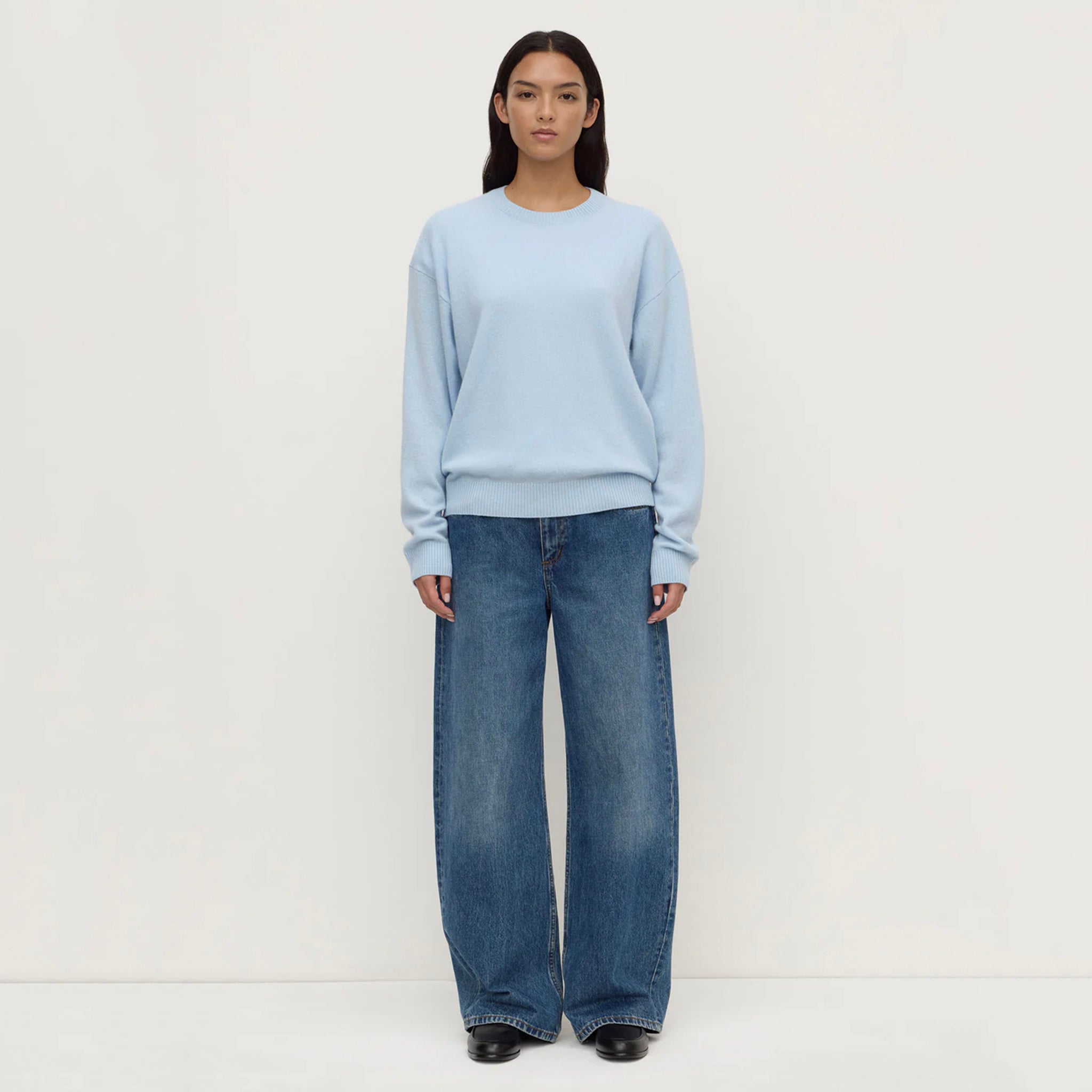 Assembly Label Carter Brushed Merino Wool Sweater - Breeze modeled by a woman in light blue with wide-leg jeans.