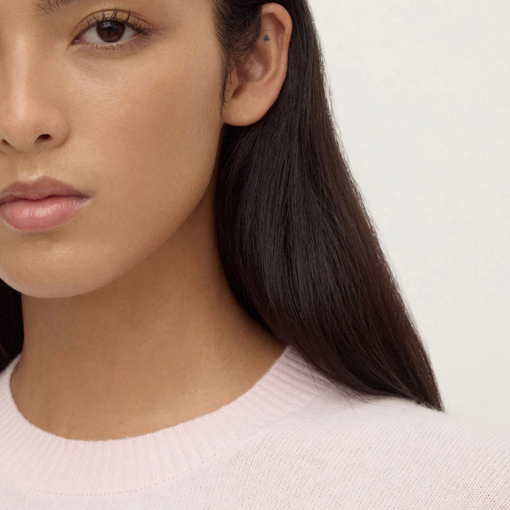 Close-up of a model wearing the Assembly Label Carter Brushed Merino Wool Sweater - Floss, featuring a ribbed neckline.