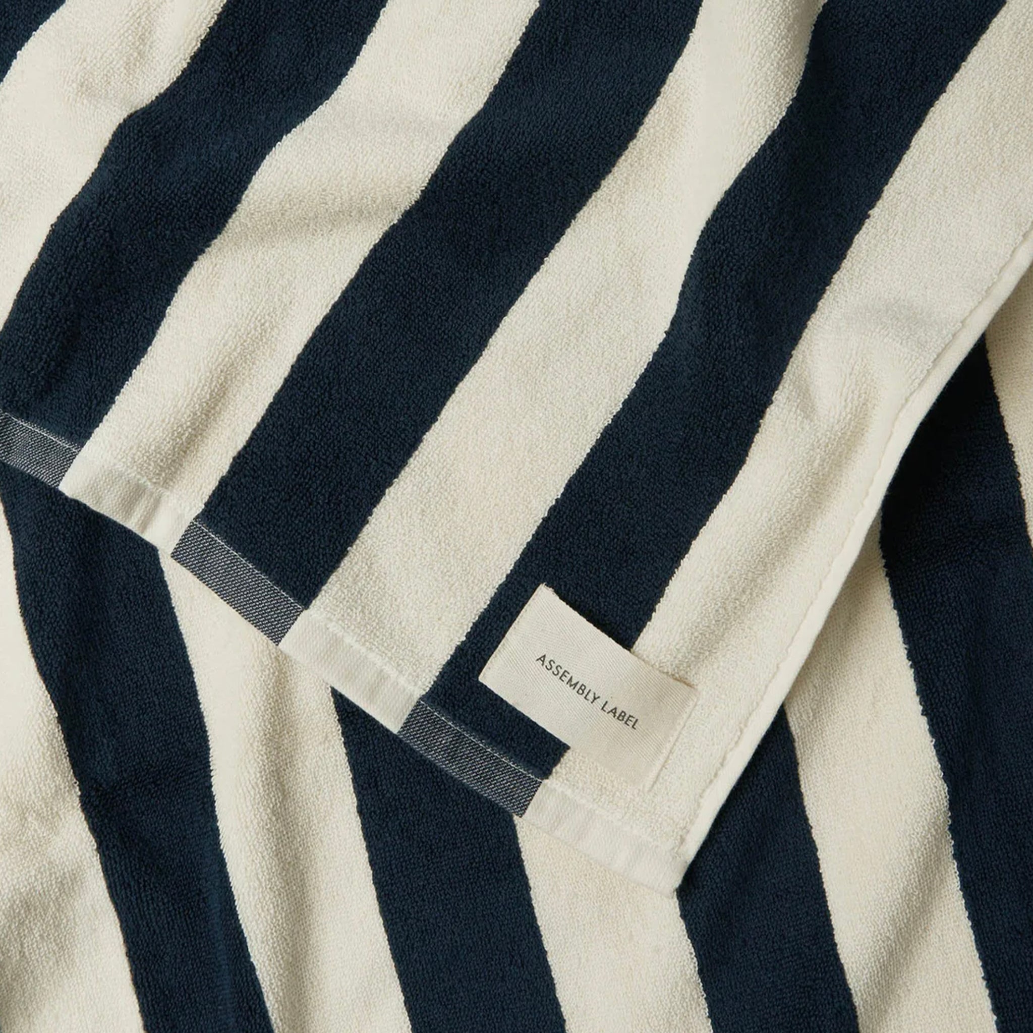 Navy and cream striped bath towel on a white background.