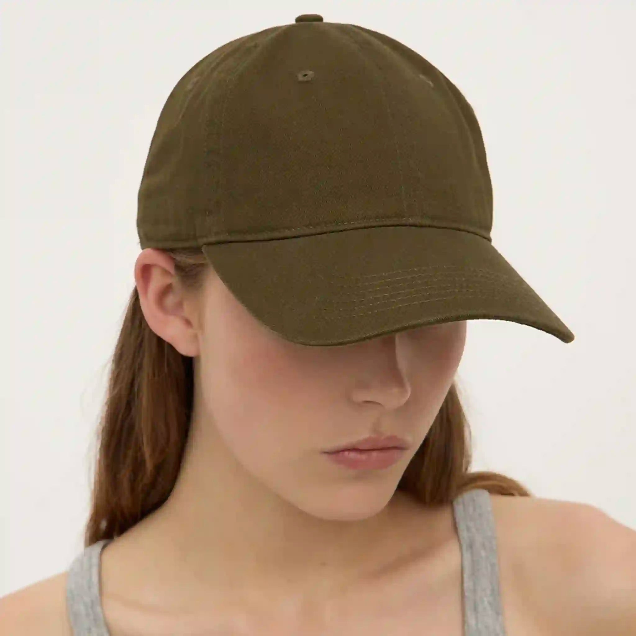 Person wearing an olive green cap against a plain background