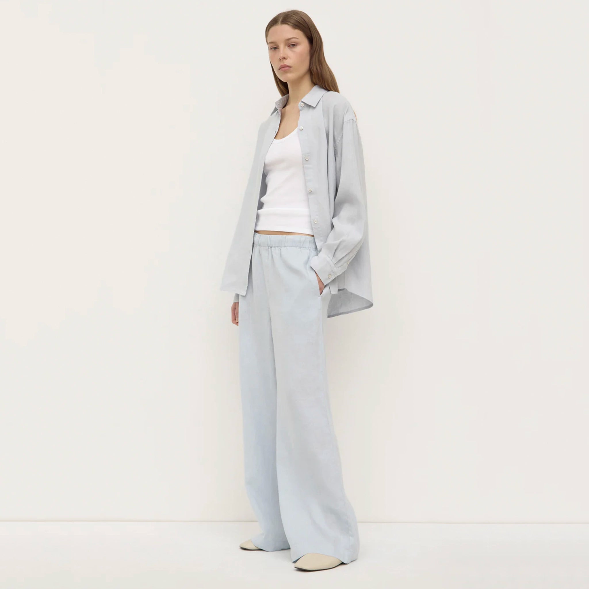 Woman wearing a light gray outfit on a white background