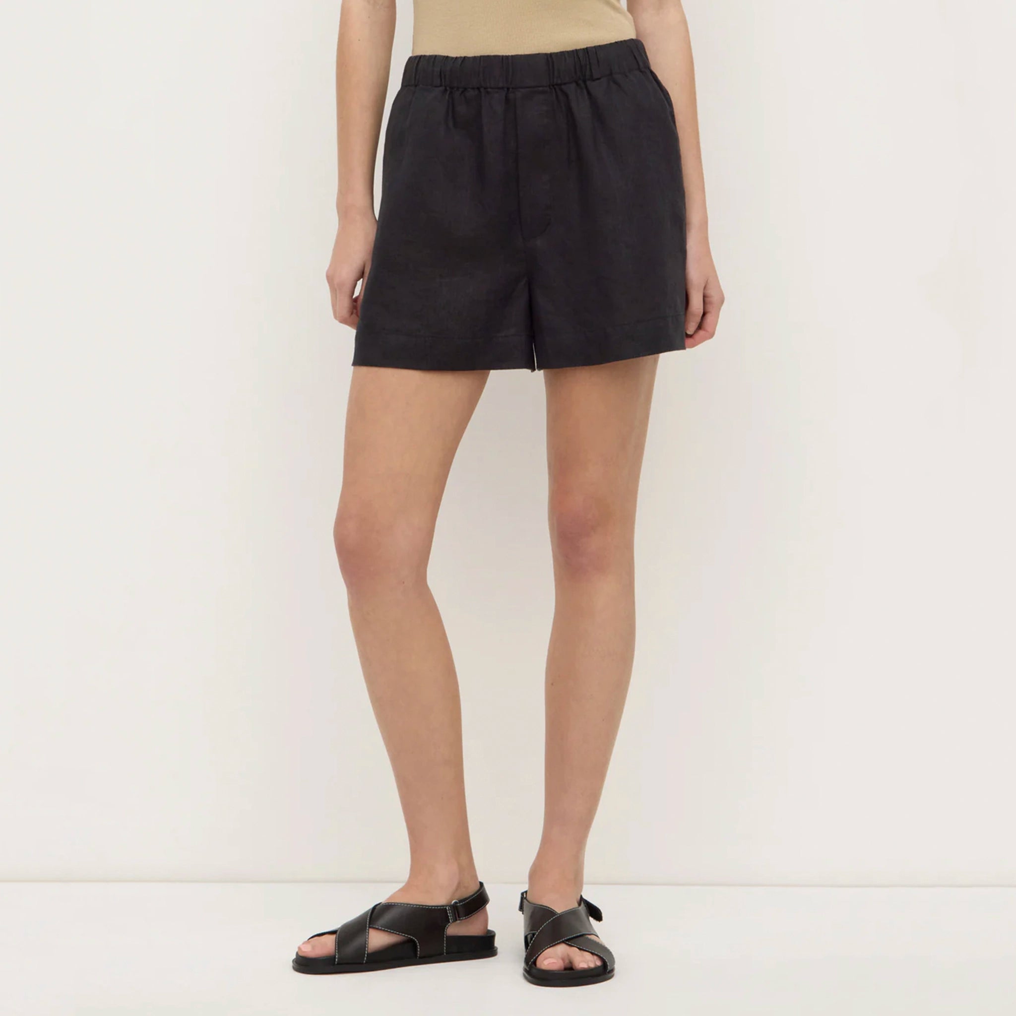 Person wearing black shorts on a white background