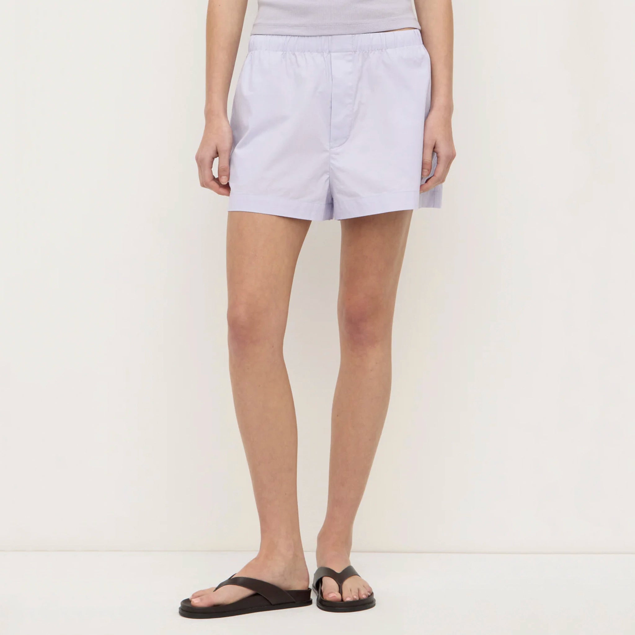 Person wearing light purple shorts on a white background