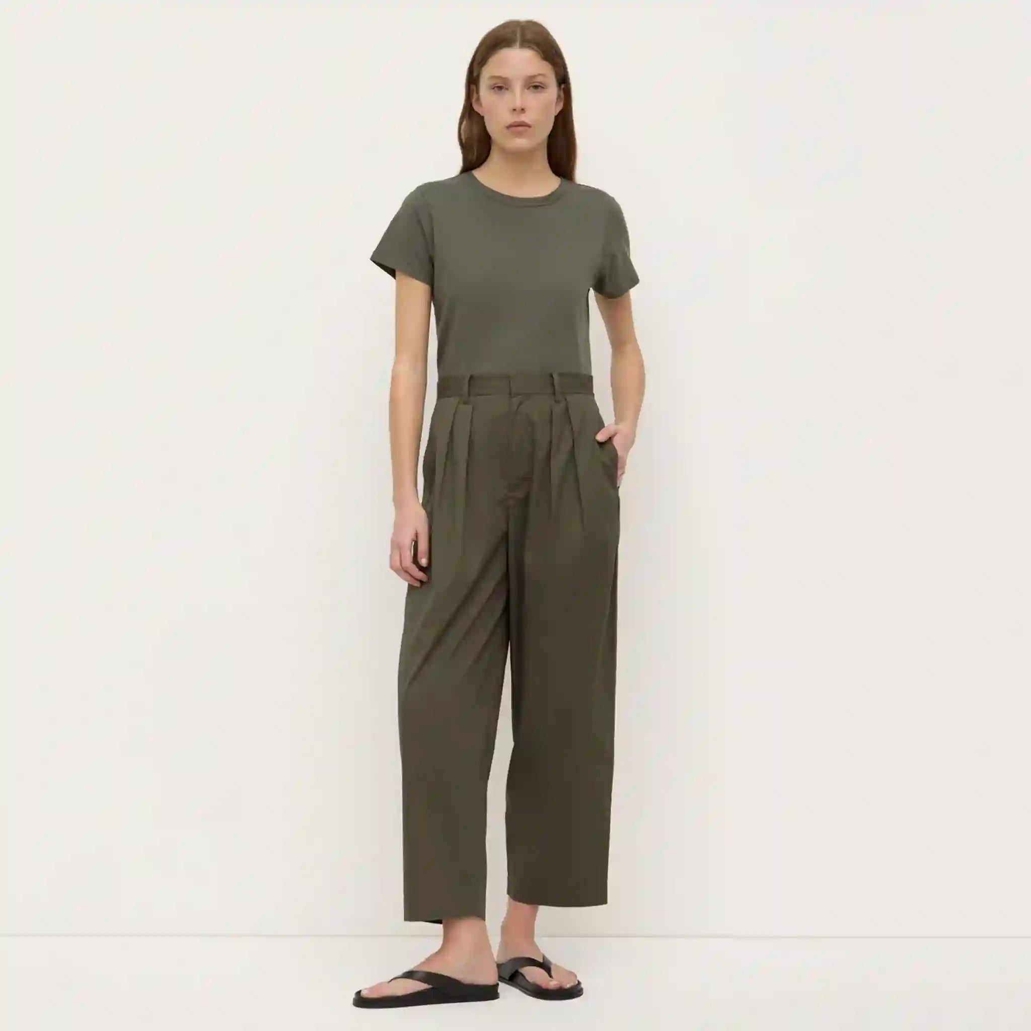 Woman wearing a green jumpsuit against a white background