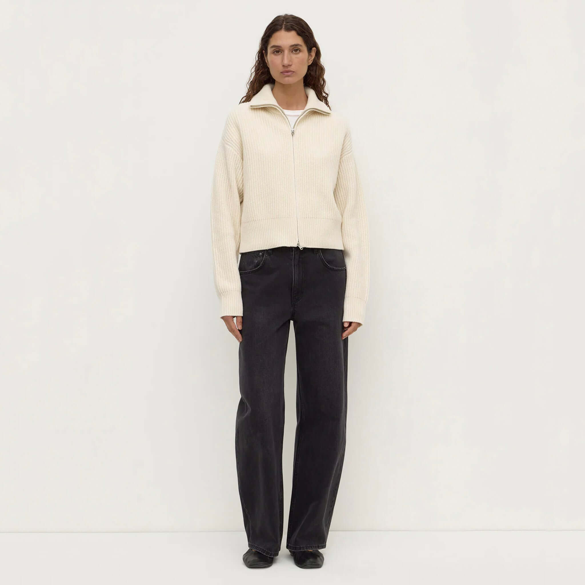 Model wearing Assembly Label Kaia Wool Zip Sweater in Antique White with black trousers.