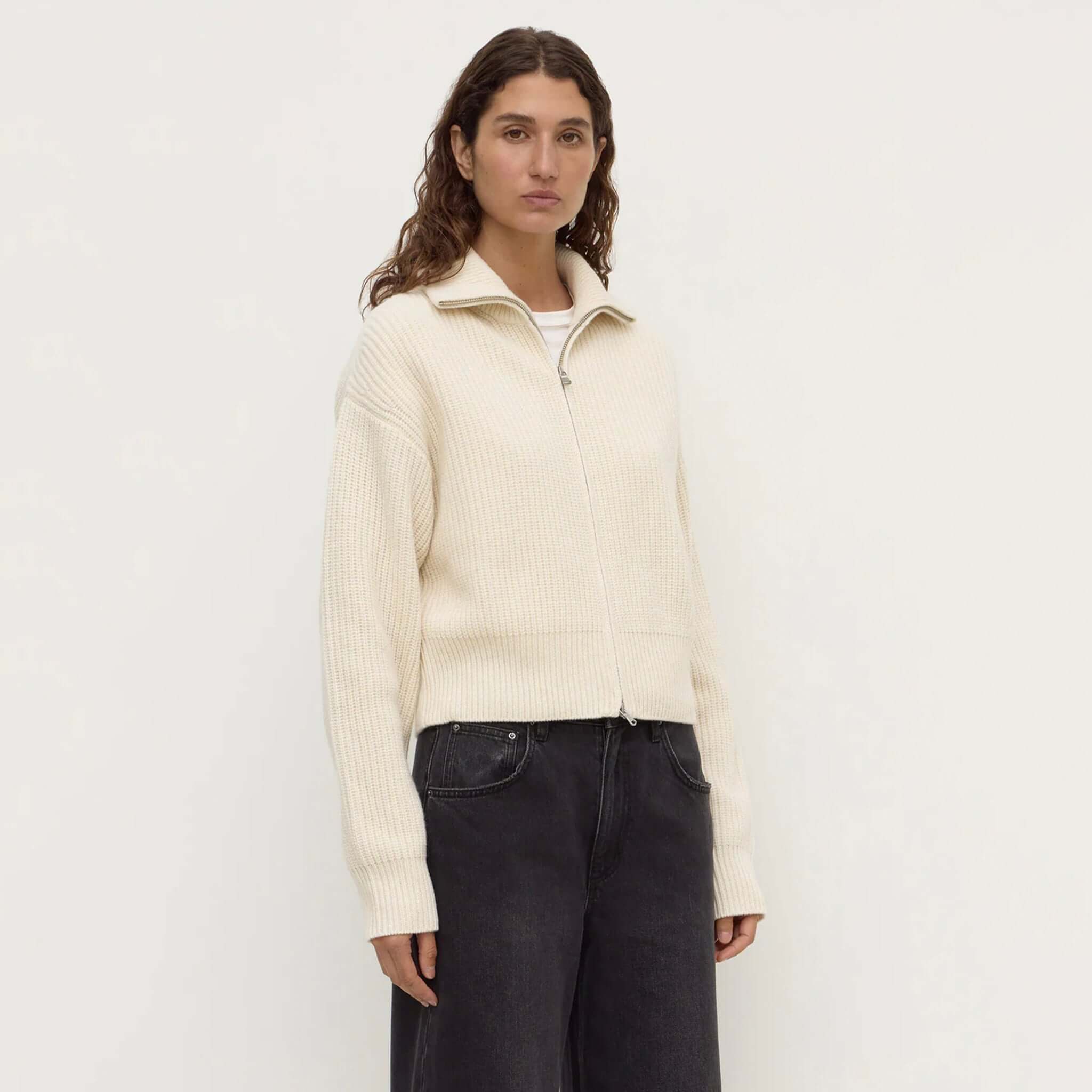 Model wearing Assembly Label Kaia Wool Zip Sweater in Antique White, a stylish wool zip sweater with a funnel neck.