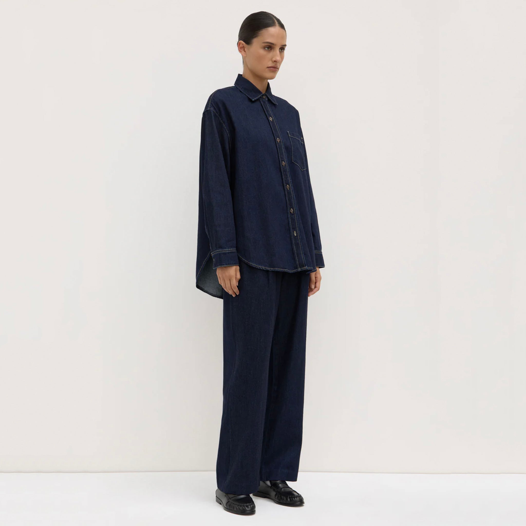 Person wearing a navy blue outfit on a white background