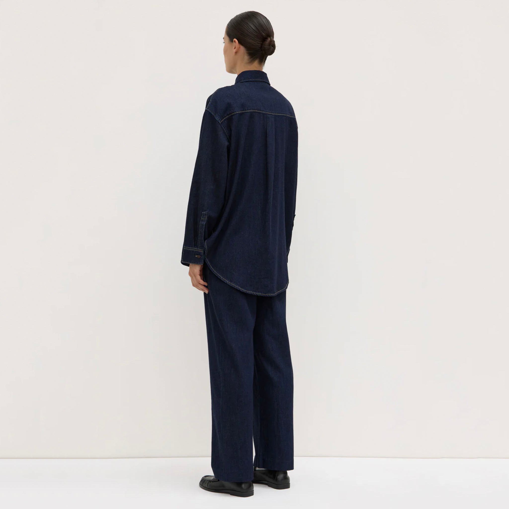 Person wearing a navy blue outfit against a white background