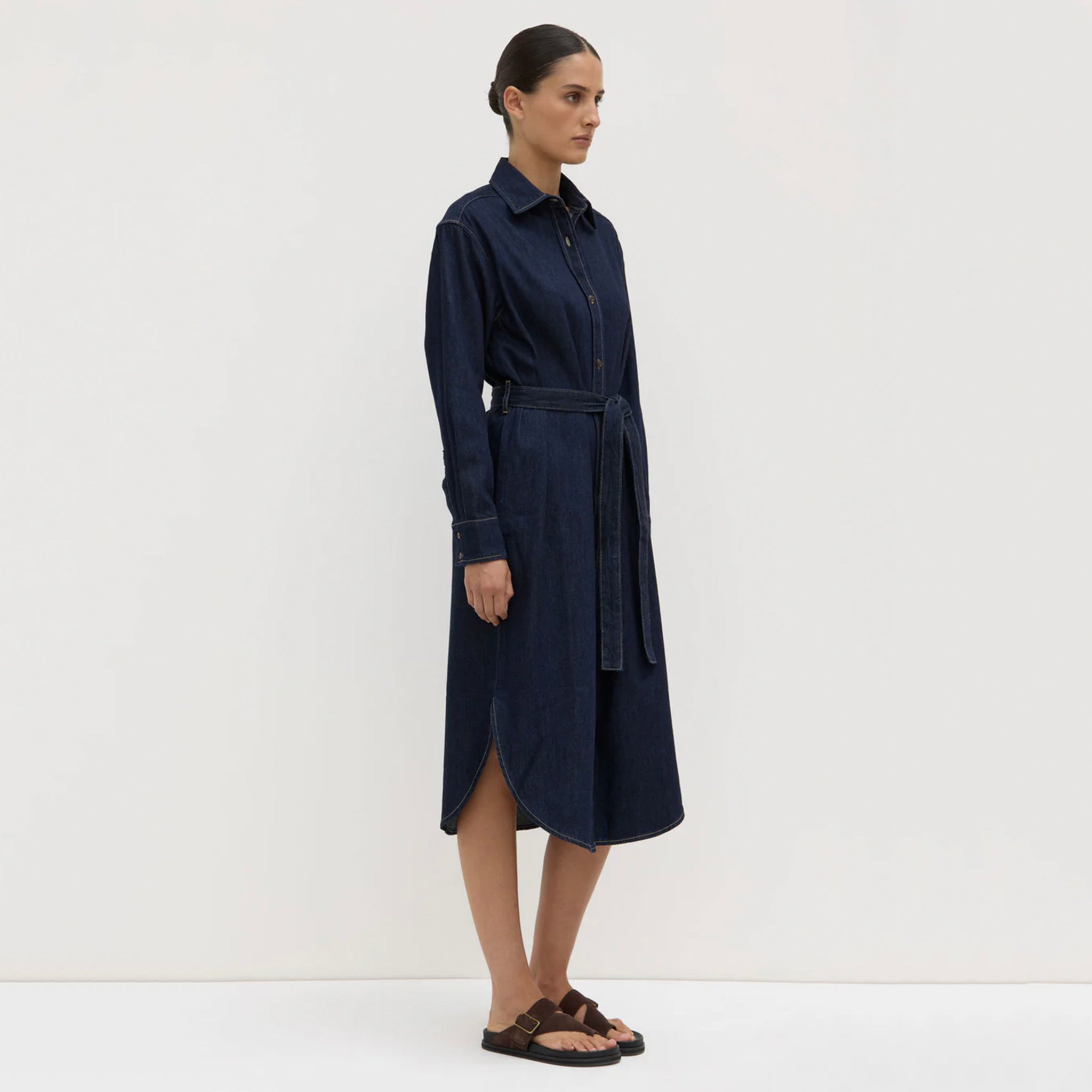 Woman wearing a navy blue dress against a white background