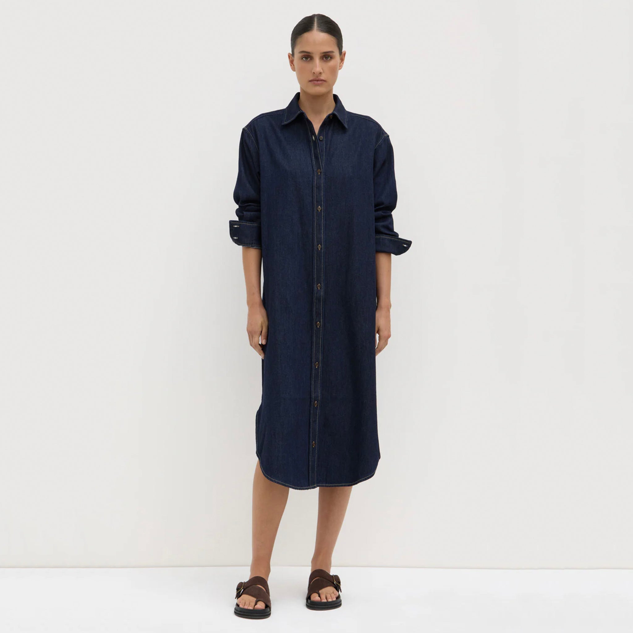 Woman wearing a navy blue dress against a white background