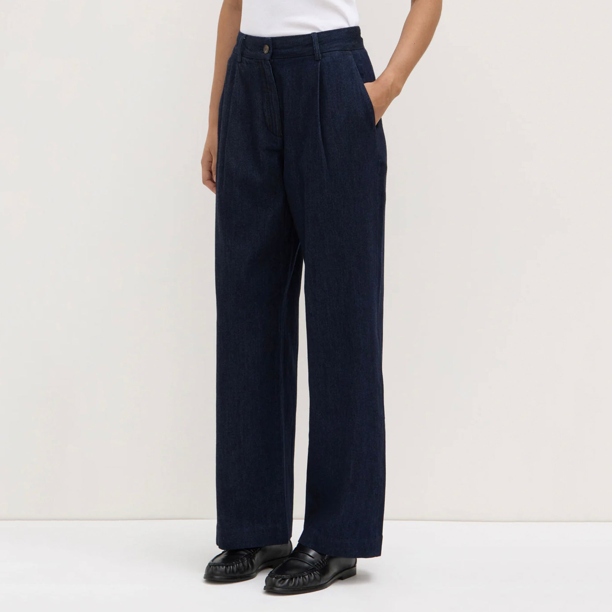 Person wearing navy wide-leg pants on a white background