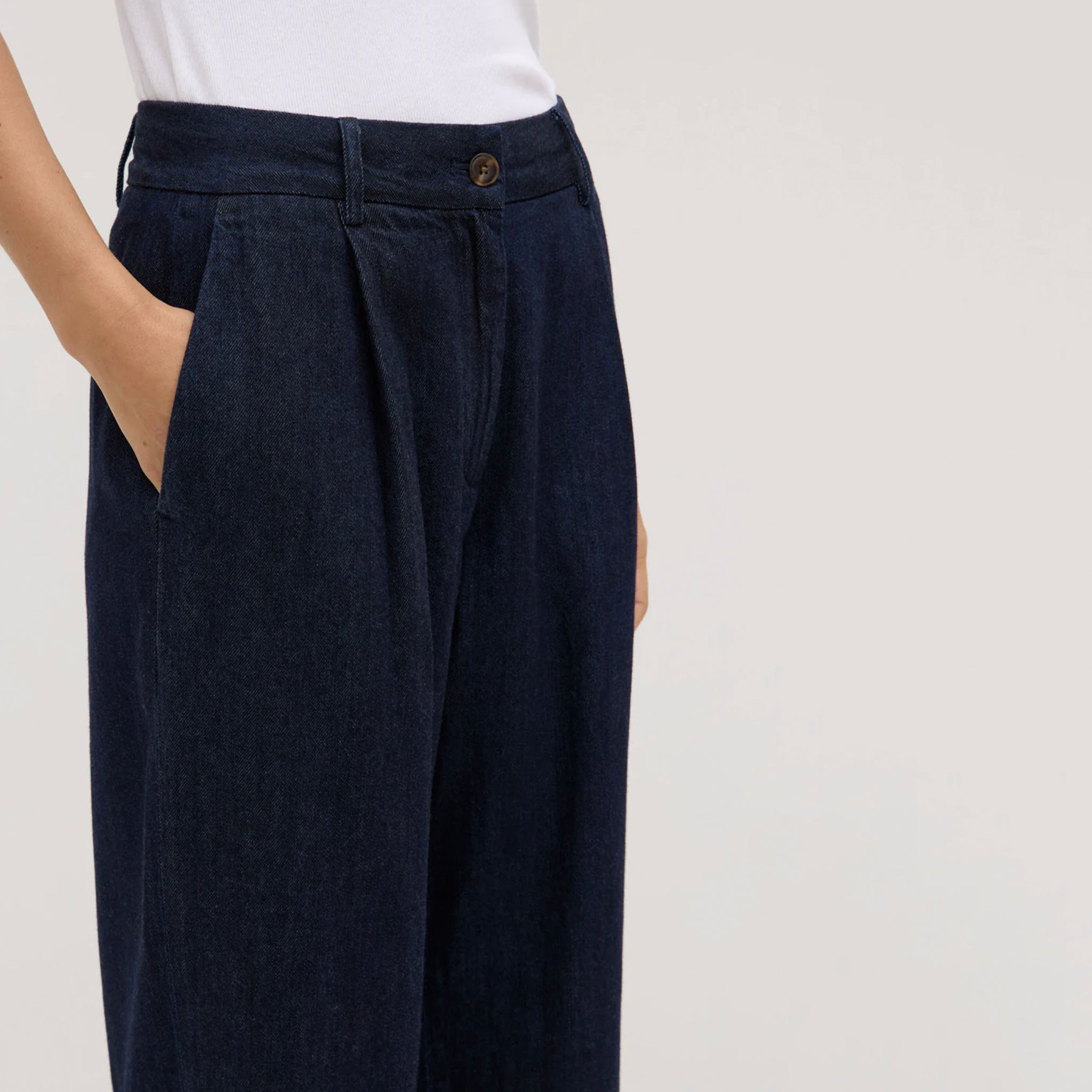 Navy blue pants worn by a person on a white background