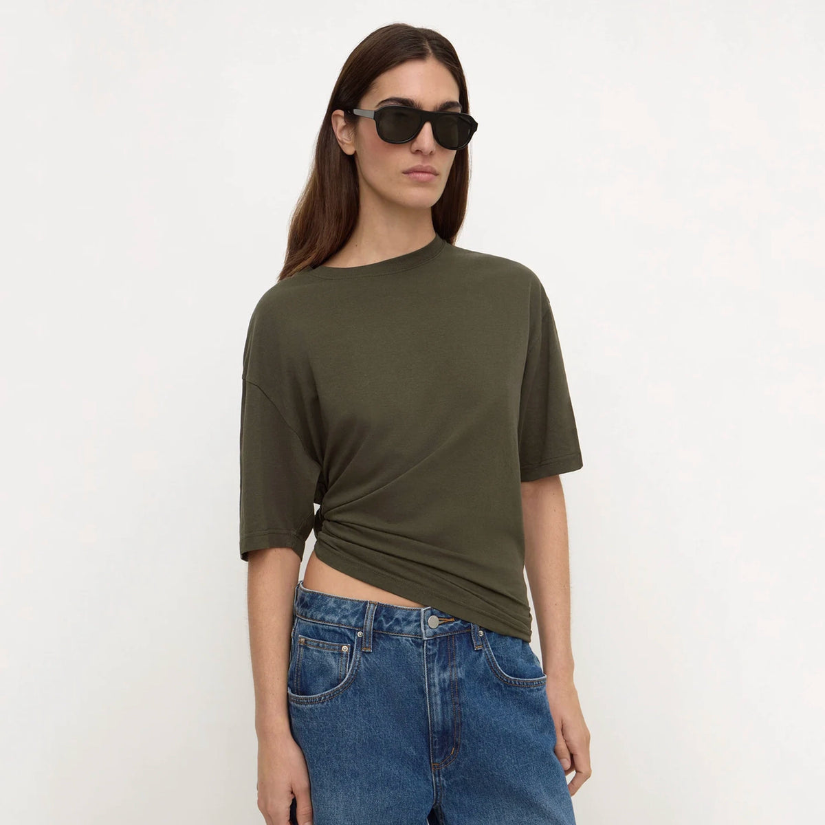 Assembly Label Kira Cotton Hemp Tee - Dark Military, front view on model with sunglasses, hem tucked at waist