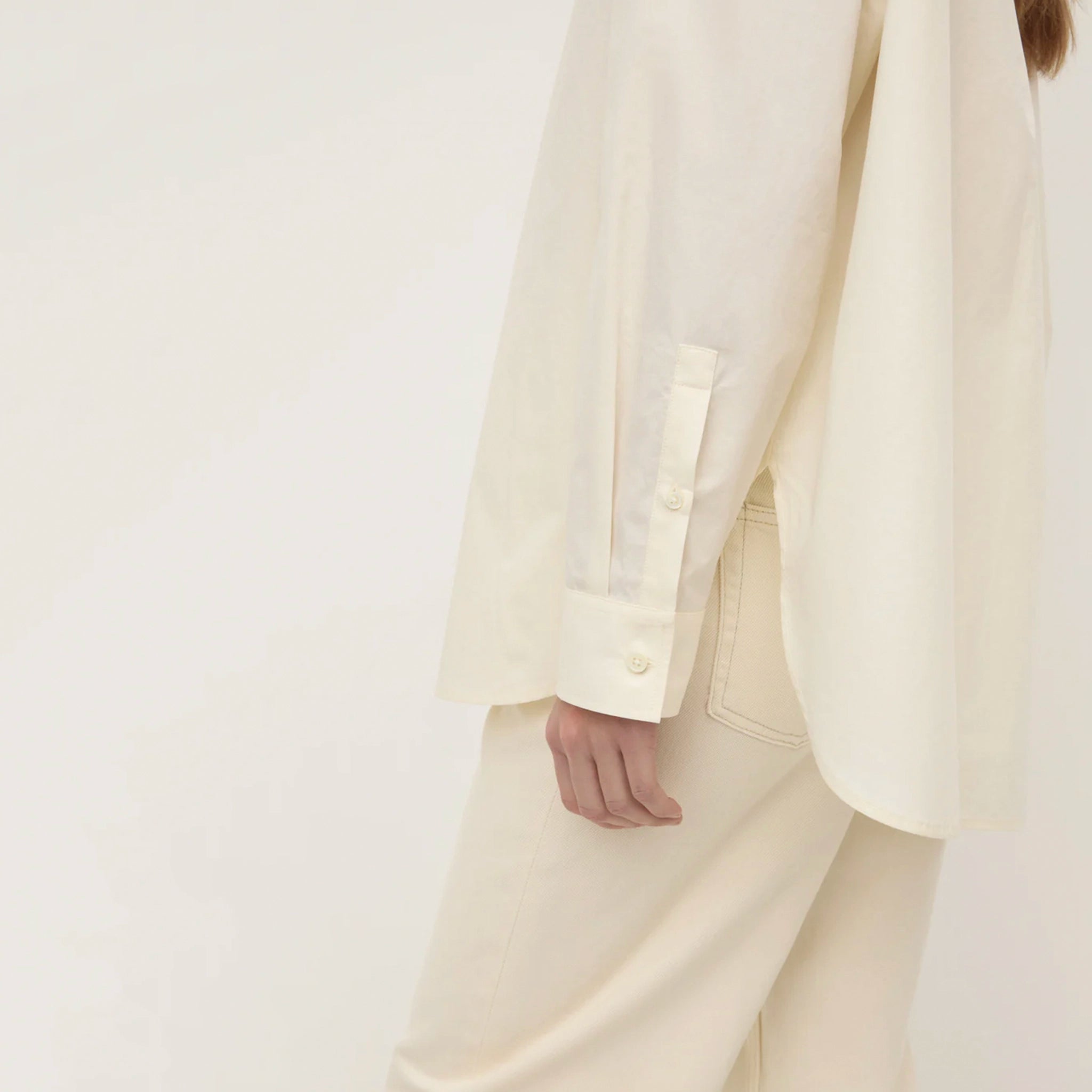 Person wearing a white suit on a plain background