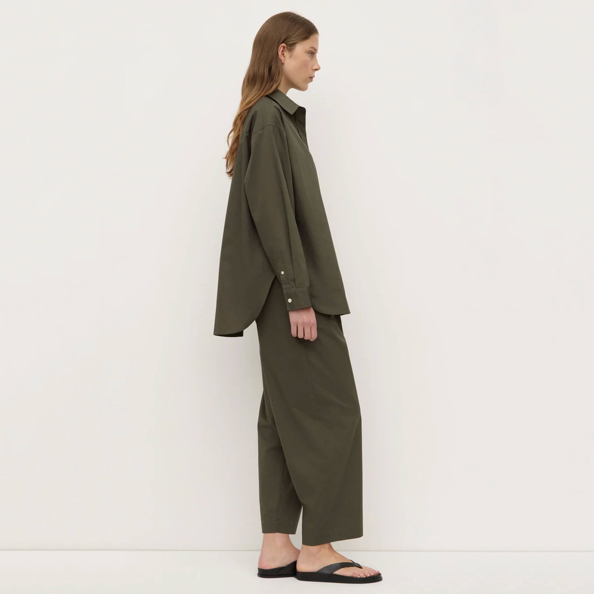 Woman wearing a green outfit standing against a white background