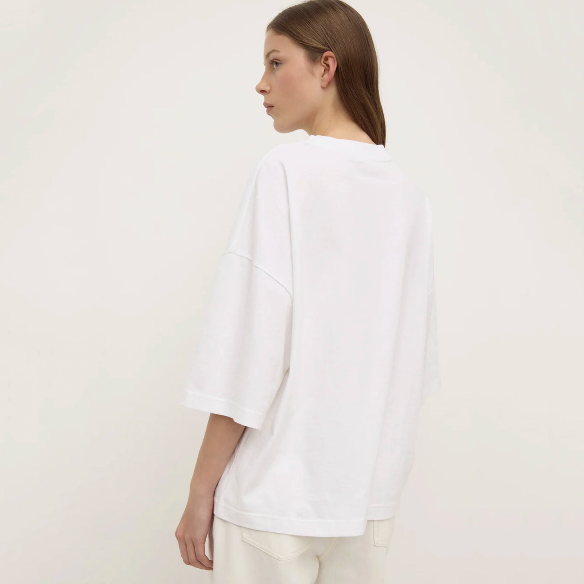 Person wearing a white shirt on a plain background