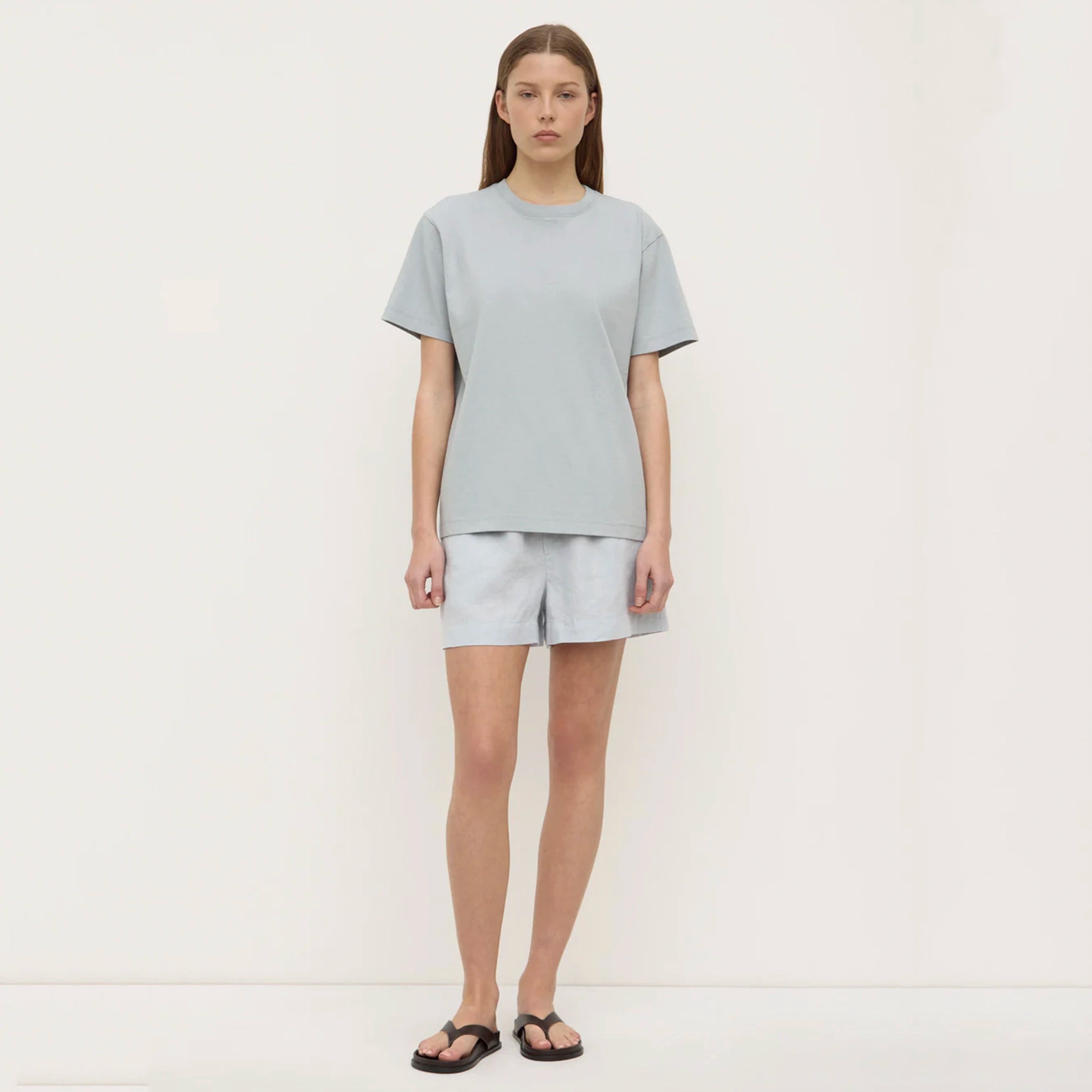 Person wearing a light blue t-shirt and pants on a plain background