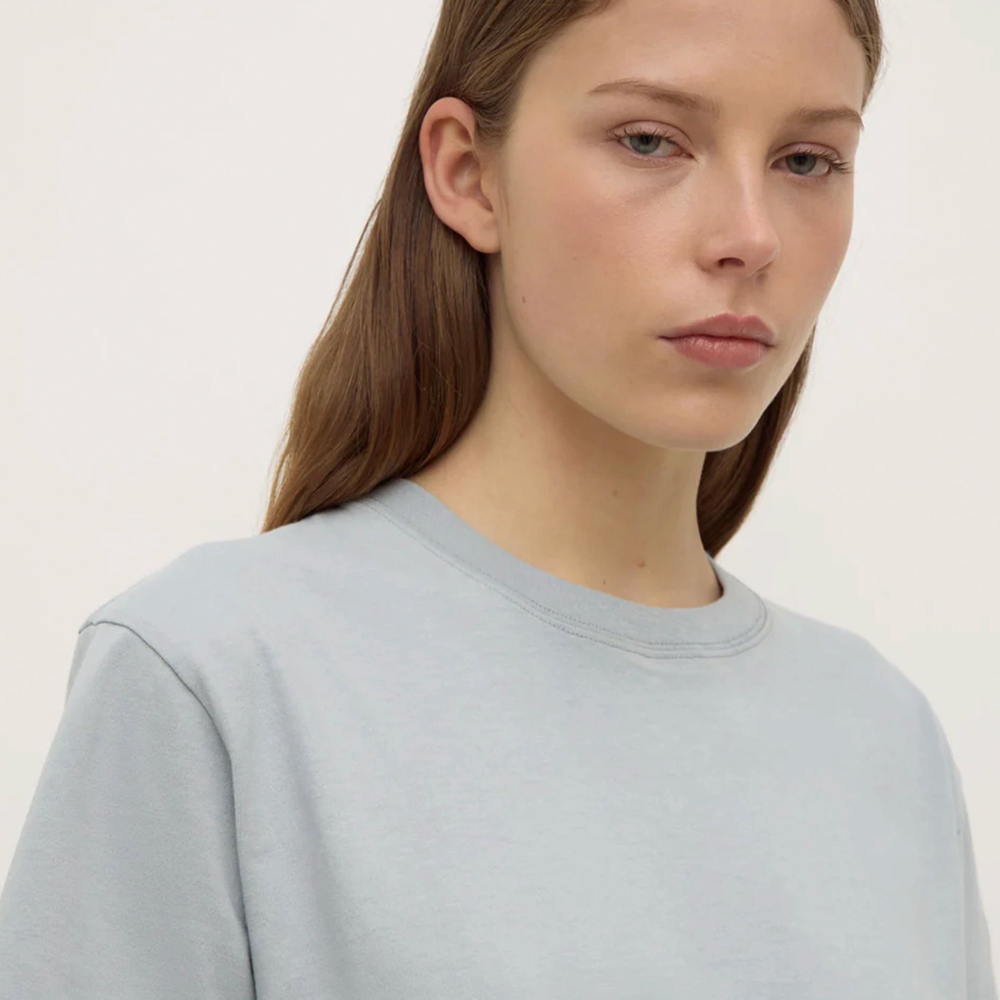 Person wearing a light blue t-shirt and pants on a plain background