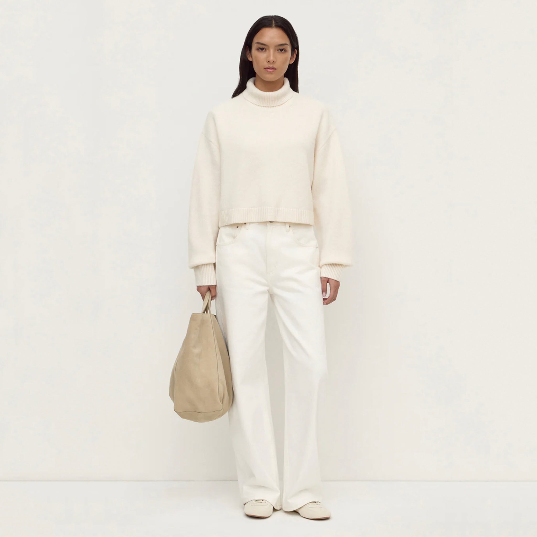 Assembly Label Paris Wool & Cashmere Knit Turtleneck - White styled with wide-legged white pants and a beige handbag.