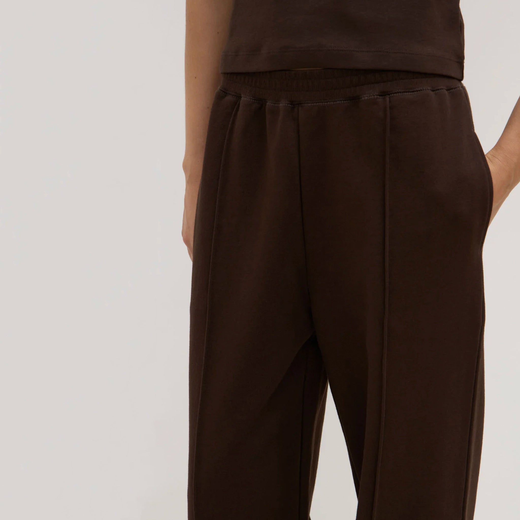 Brown pants worn by a person on a plain background