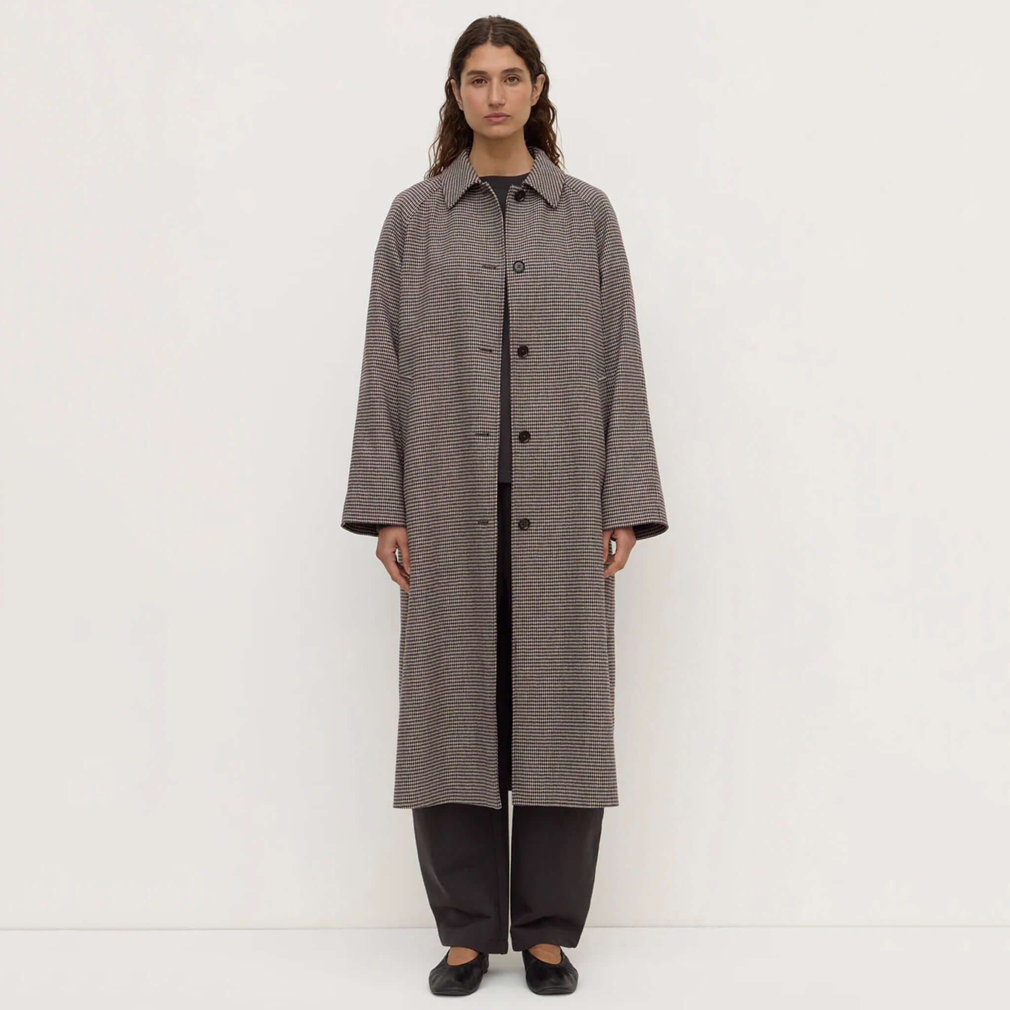 Assembly Label Solana brown black check wool coat on model, featuring button-front and long silhouette.