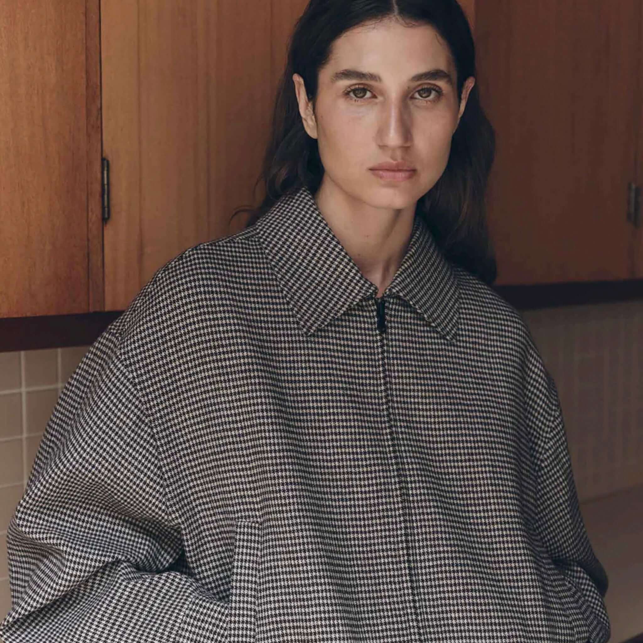 Brown black check wool jacket worn by a model, featuring a relaxed fit and stylish design.