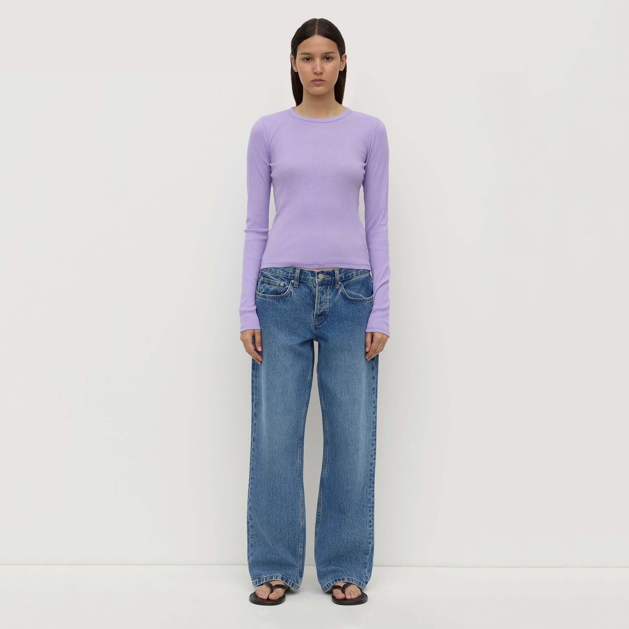 Assembly Label Zali Long Sleeve Tee - Mauve worn with wide-leg jeans, showcasing its classic crew neckline and fitted style.