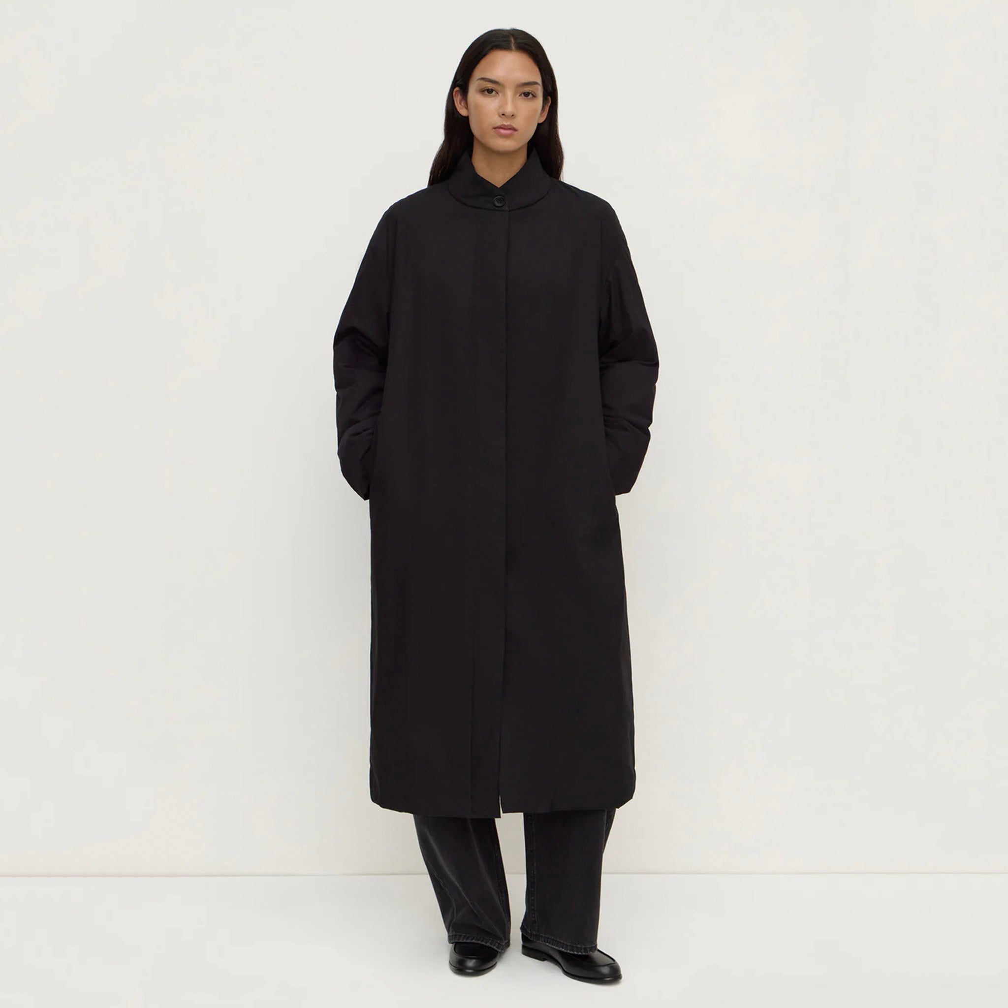 Assembly Label Zoie Padded Coat - Black worn by a model, showcasing its sleek collarless design and lightweight silhouette.