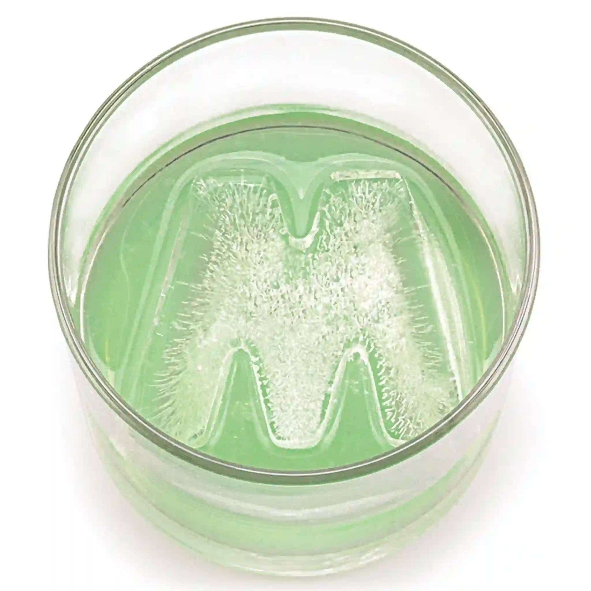 Drinks Plinks ice cube with green ice cubes in a glass.