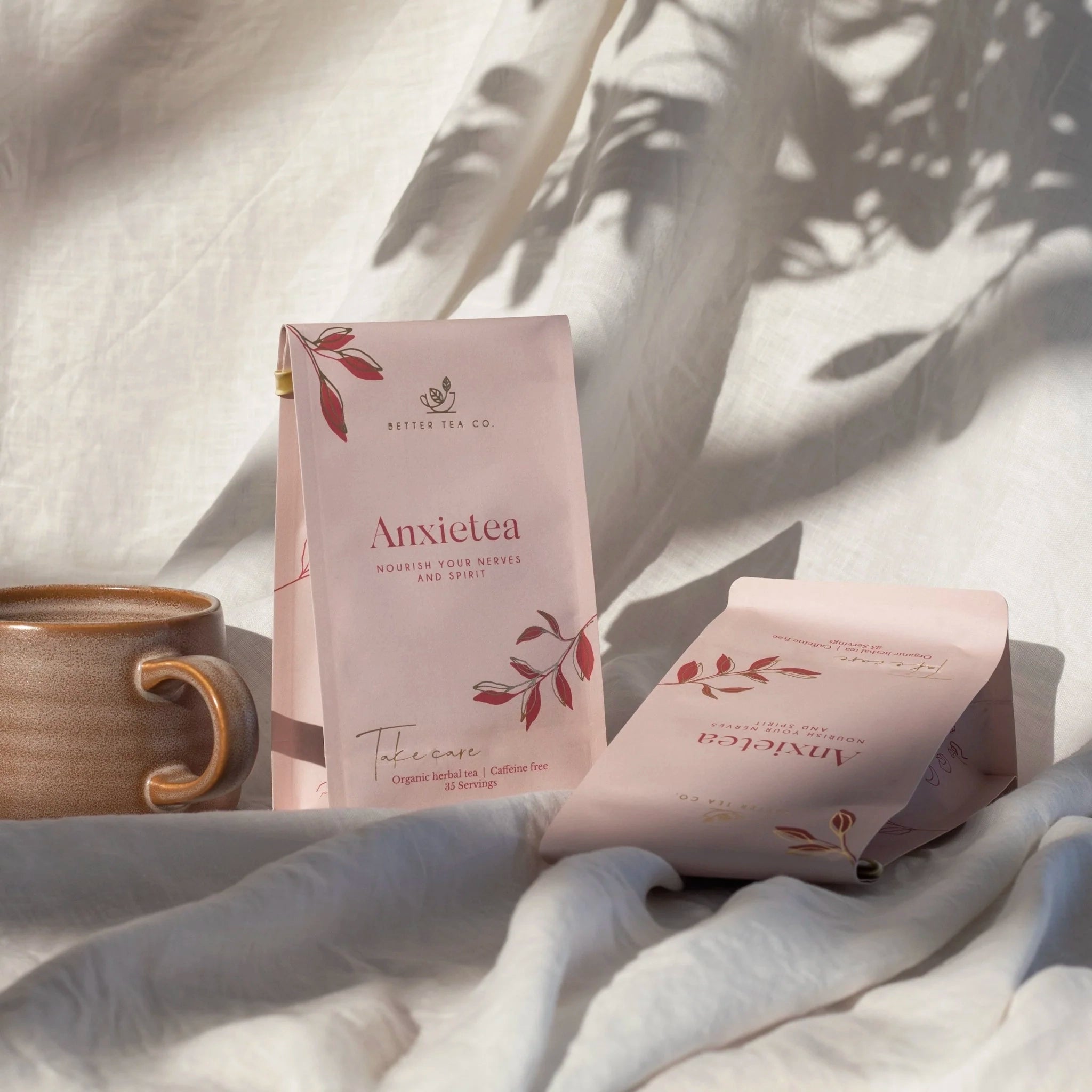 Two packages of 'Anxietae' tea on a textured surface with a cup in the background.