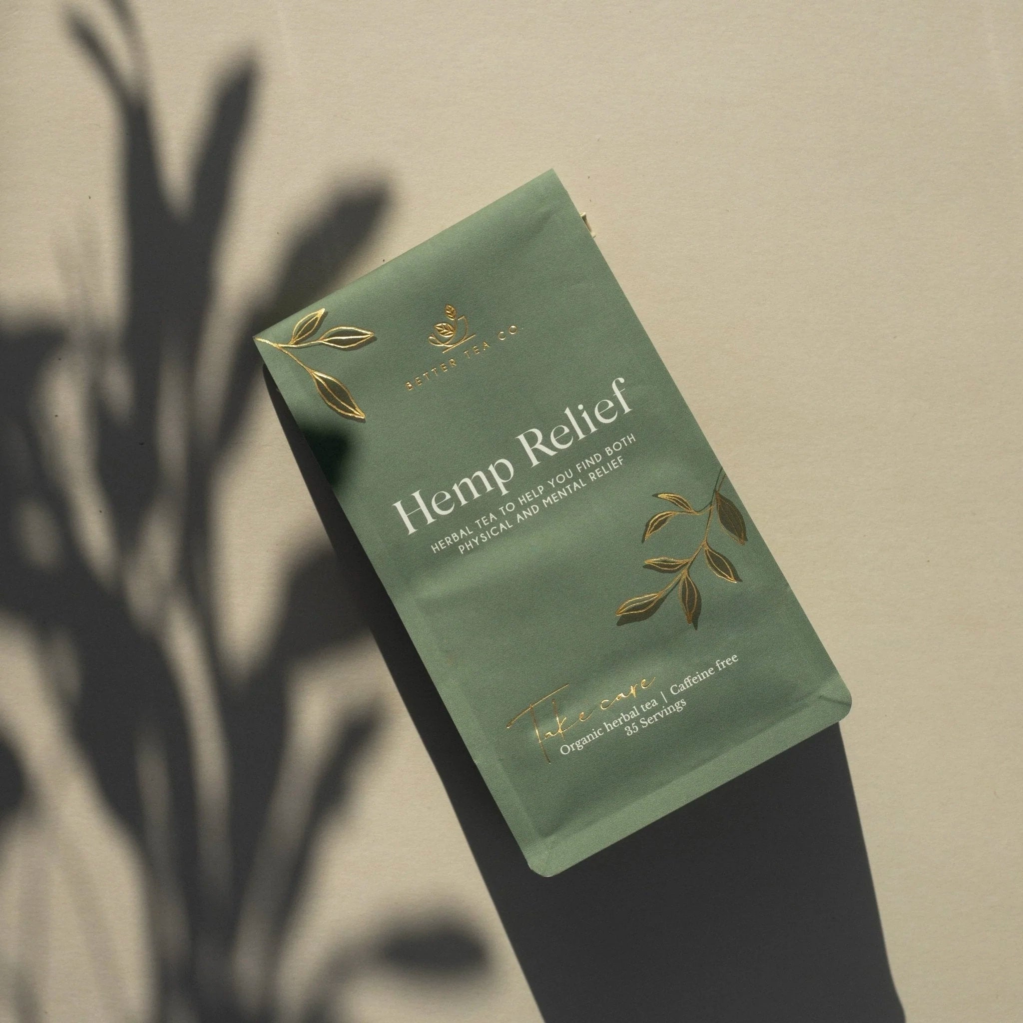 Green package of Hemp Relief tea with leaf designs on a beige background