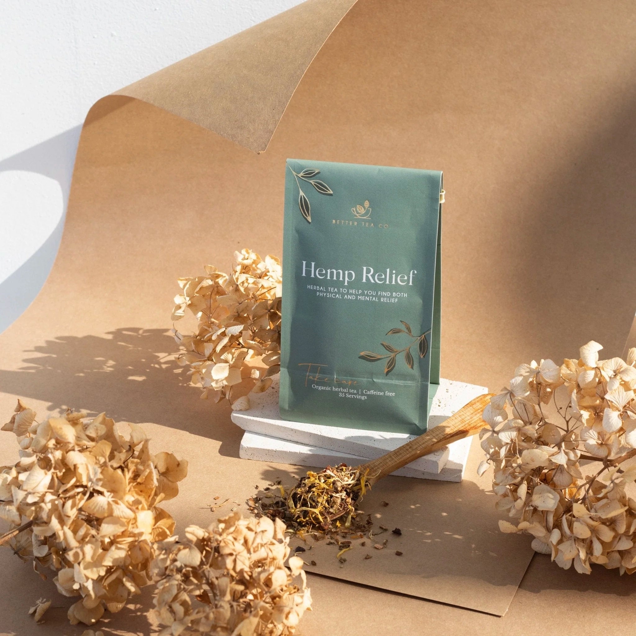 Tea package labeled 'Hemp Relief' on a brown fabric background with dried flowers.