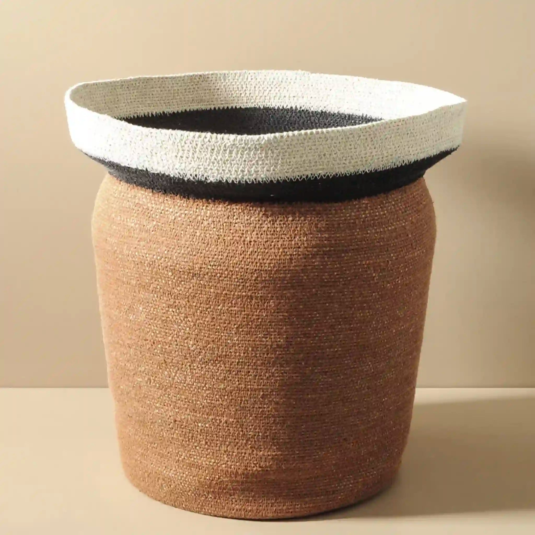Woven basket with a white top and brown body on a beige background