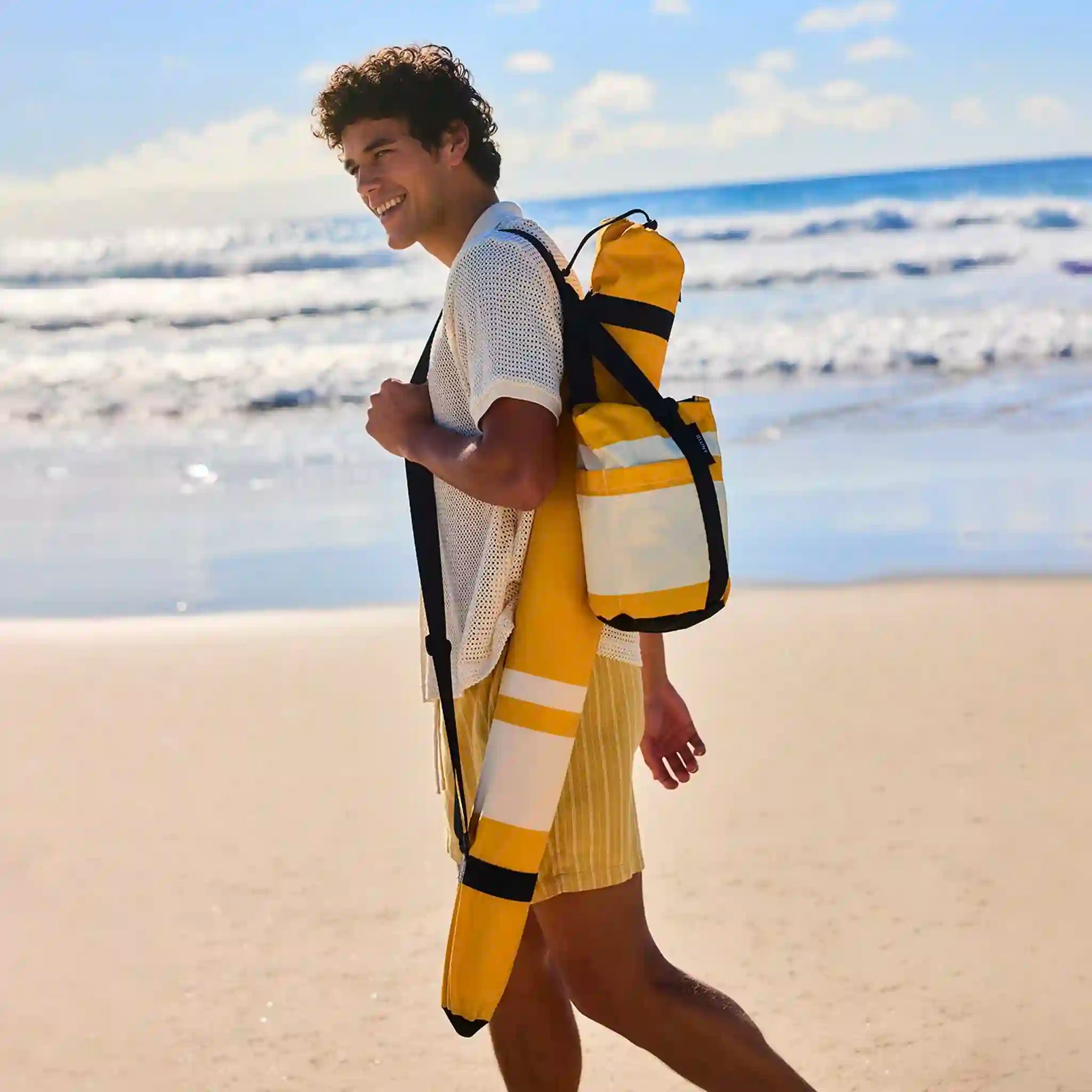 Person wearing a yellow and black backpack on a beach