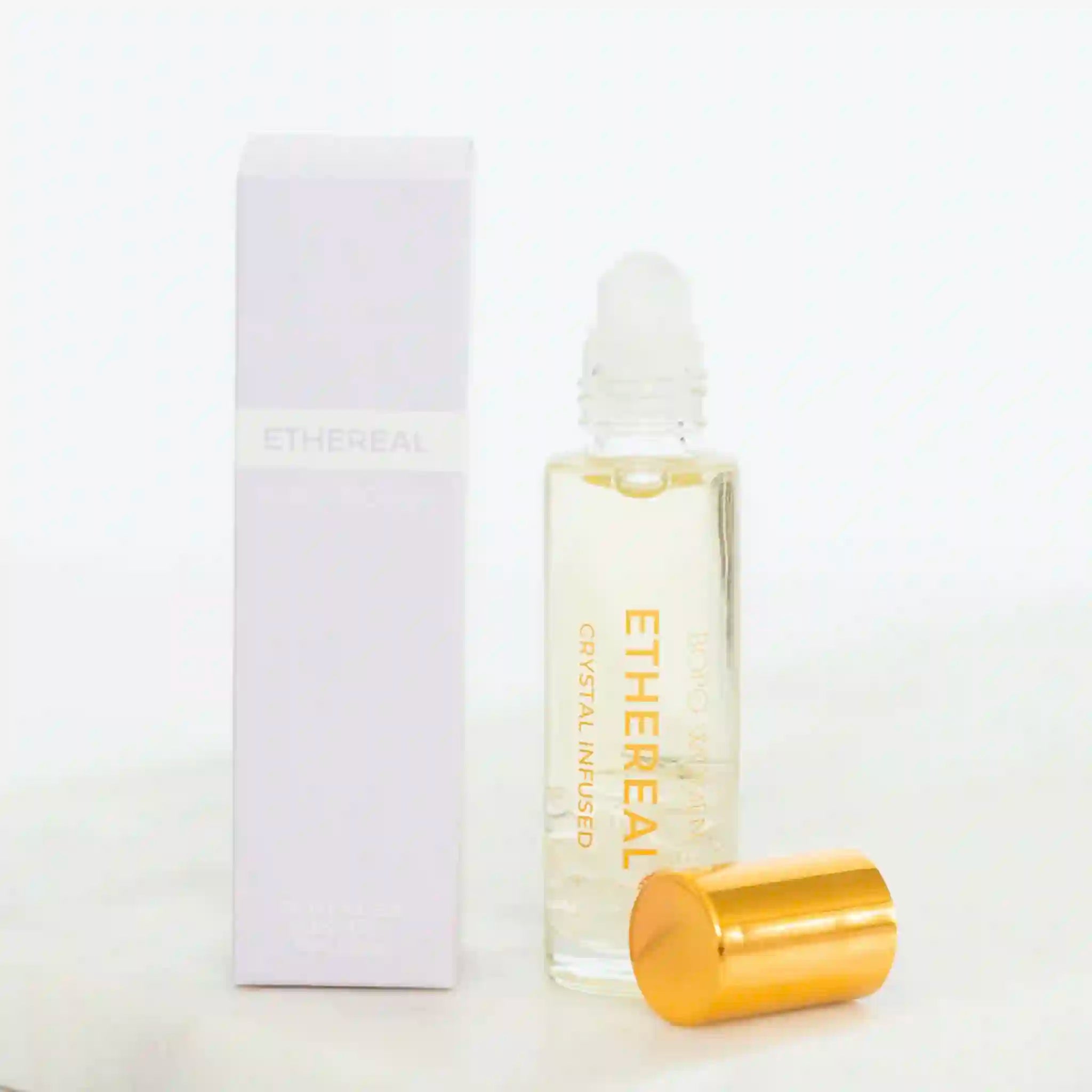 Ethereal rollerball bottle with gold cap on a white background
